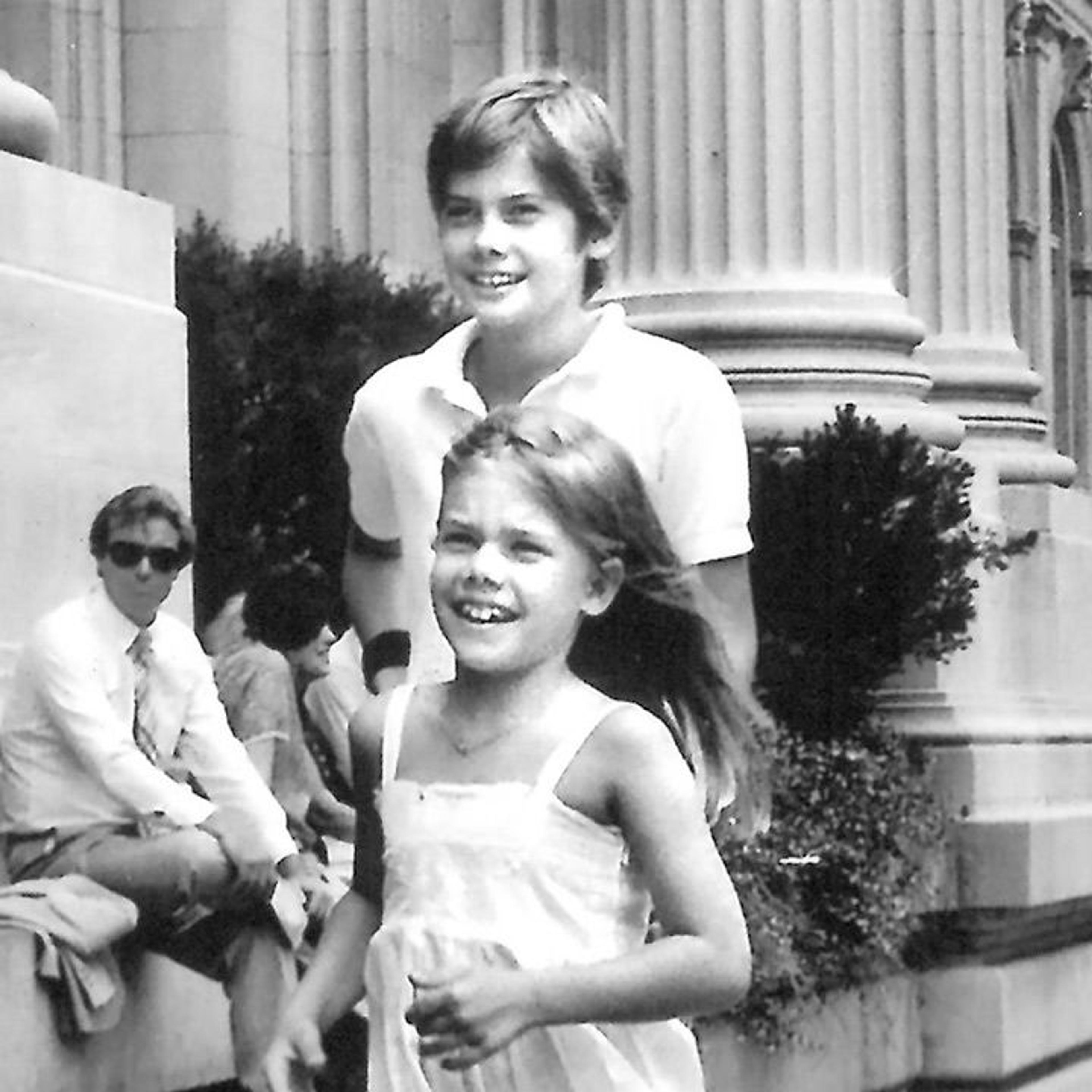 Young boy and girl running on the steps of The Met.