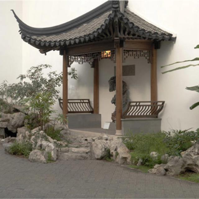 An interior courtyard with pagodas, plantings, ornamental rocks, and a fish pond
