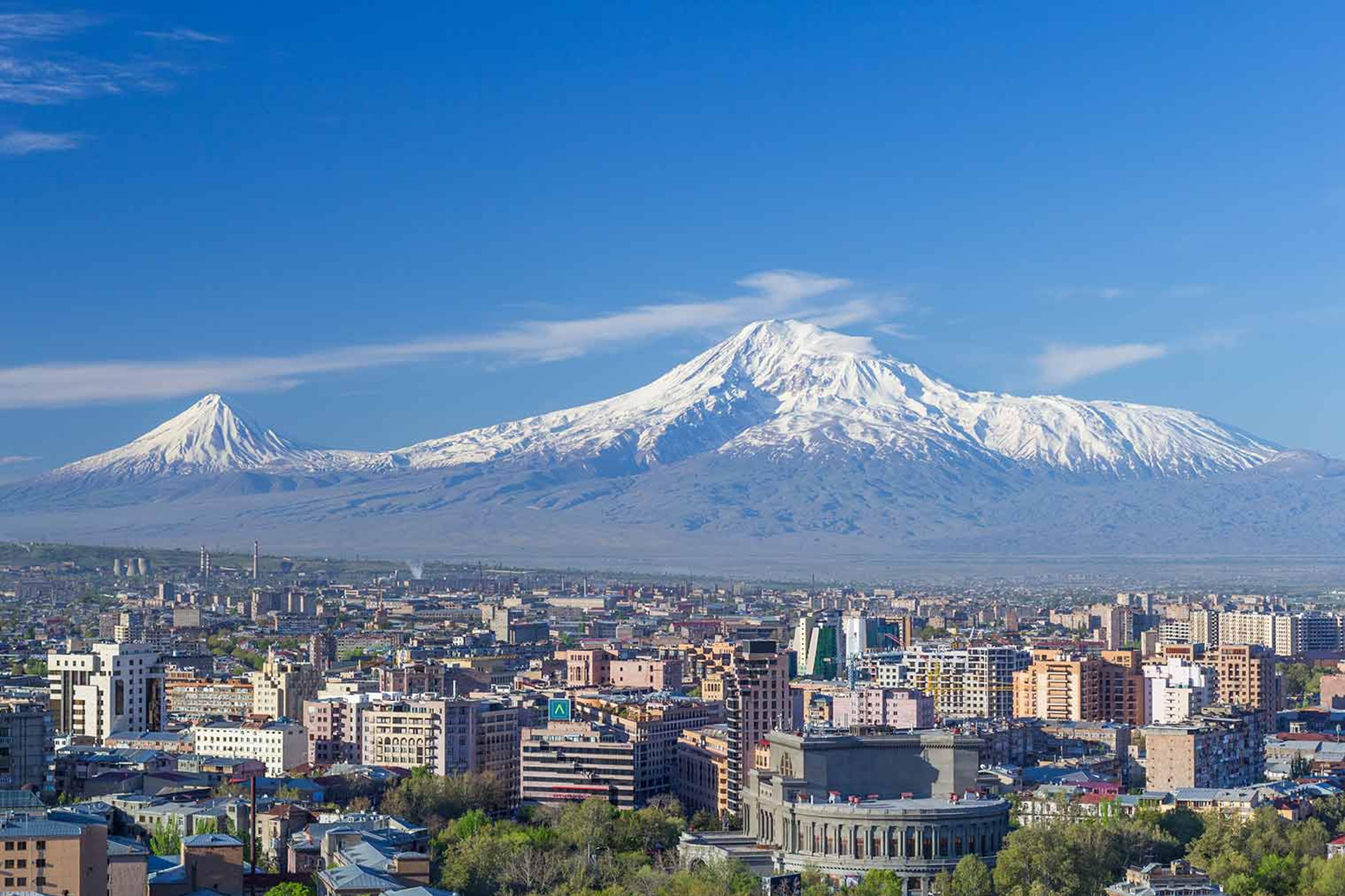 Photo of Mount Ararat against the horizon with a modern city landscape in front