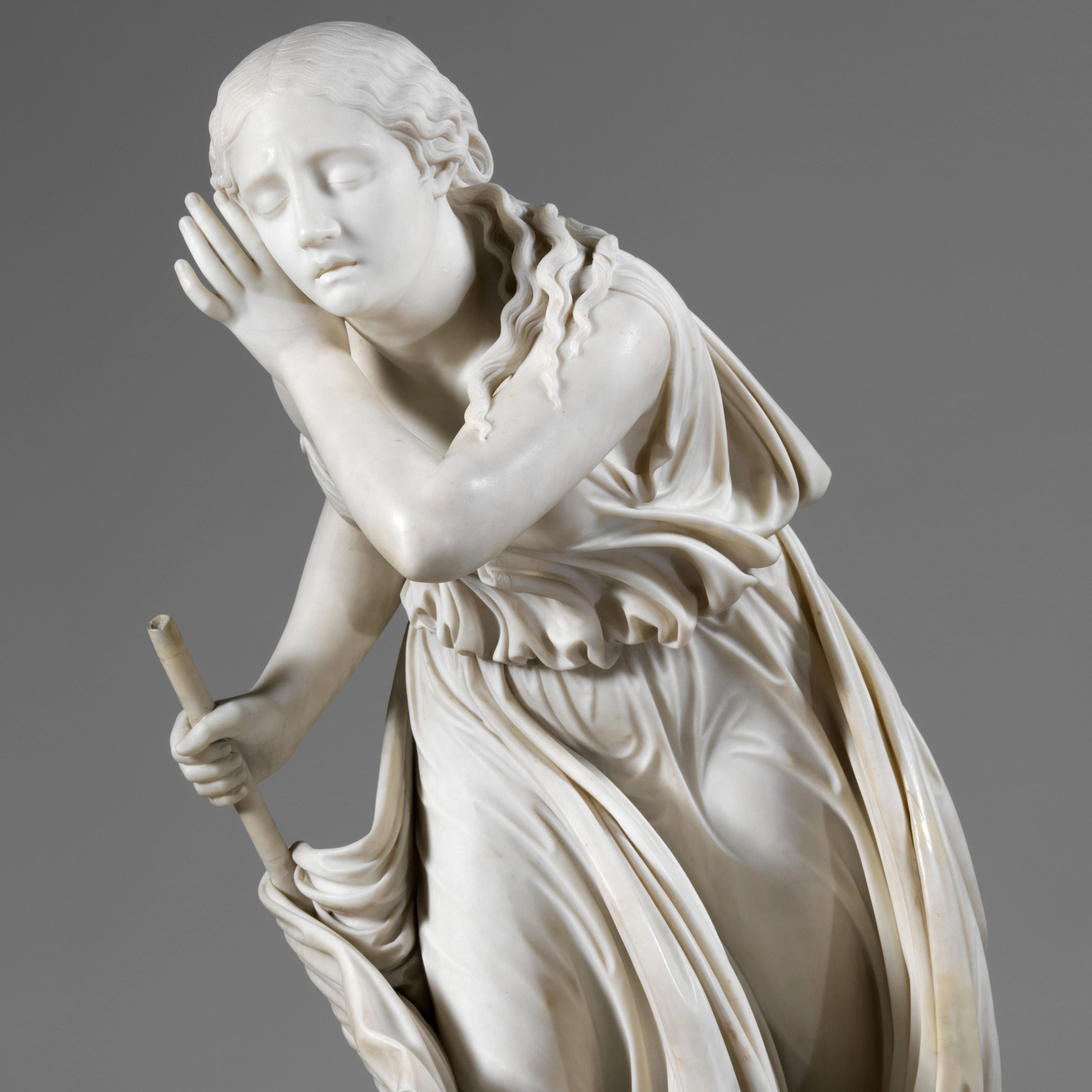 Marble sculpture of a girl, holding a staff, her eyes closed and her hand raised to her ear.