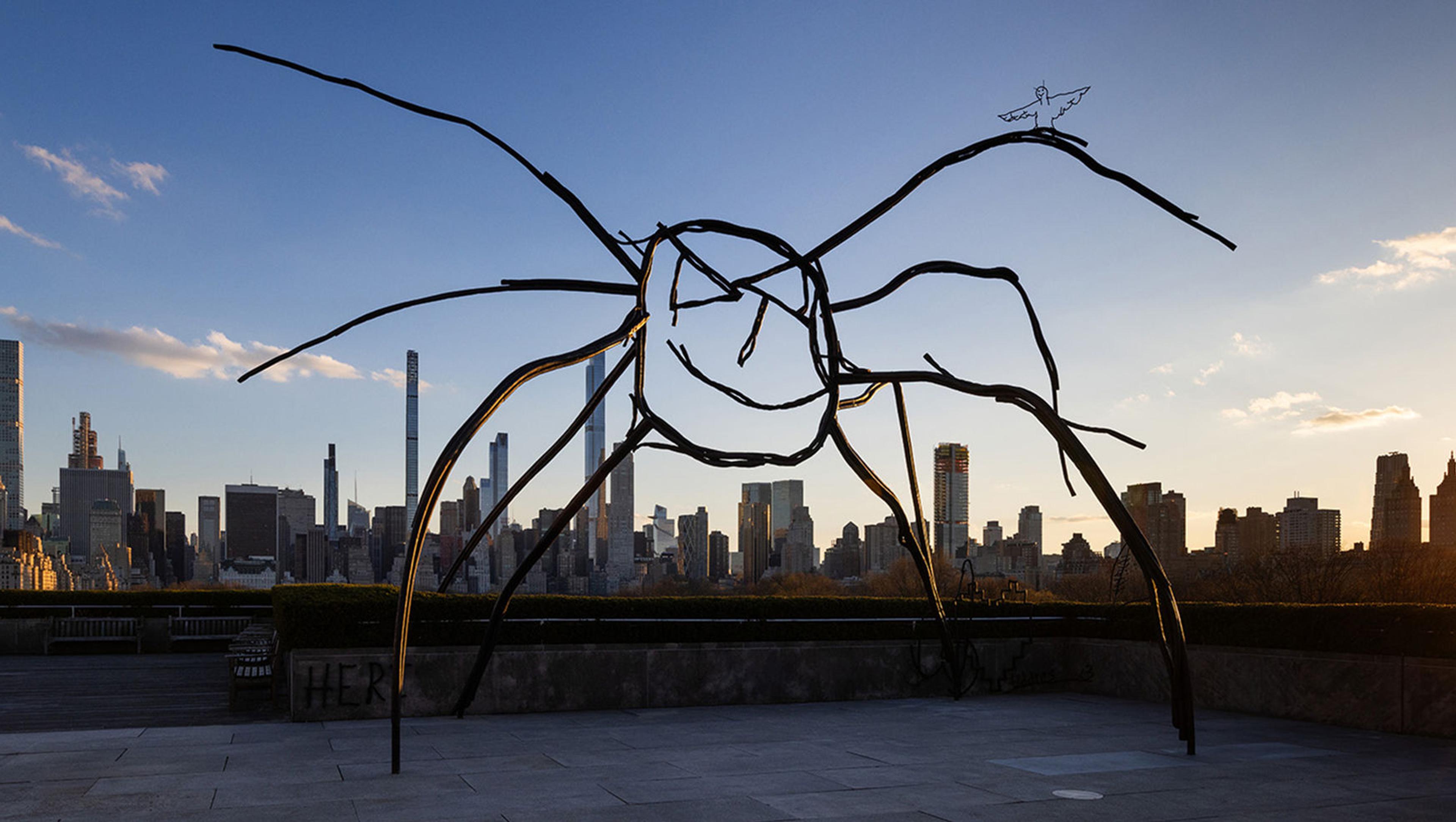 Metal scluped spider with the city skyline in the background.