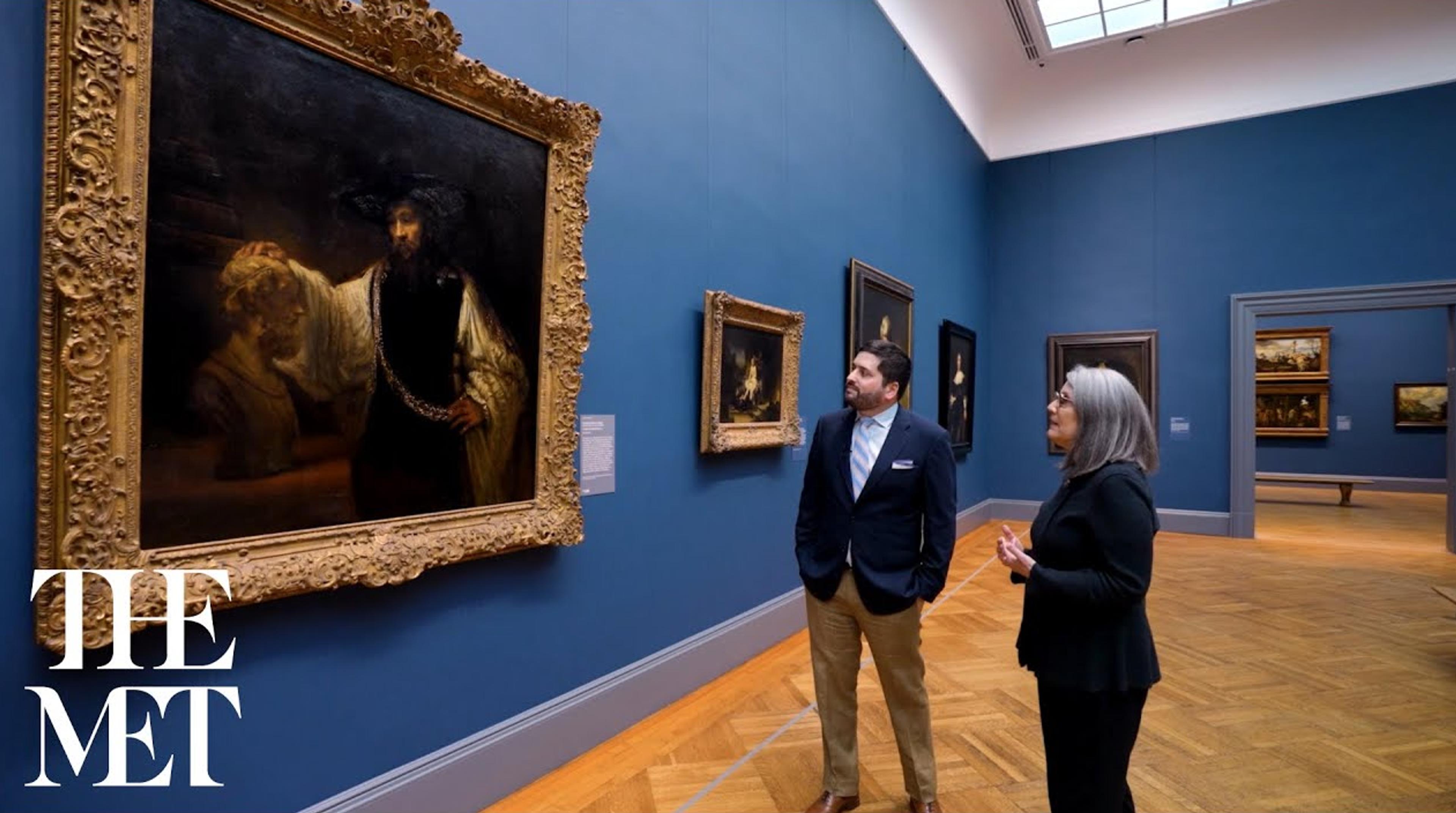 Two people stand in The Met's European Paintings galleries, looking at a work of art.