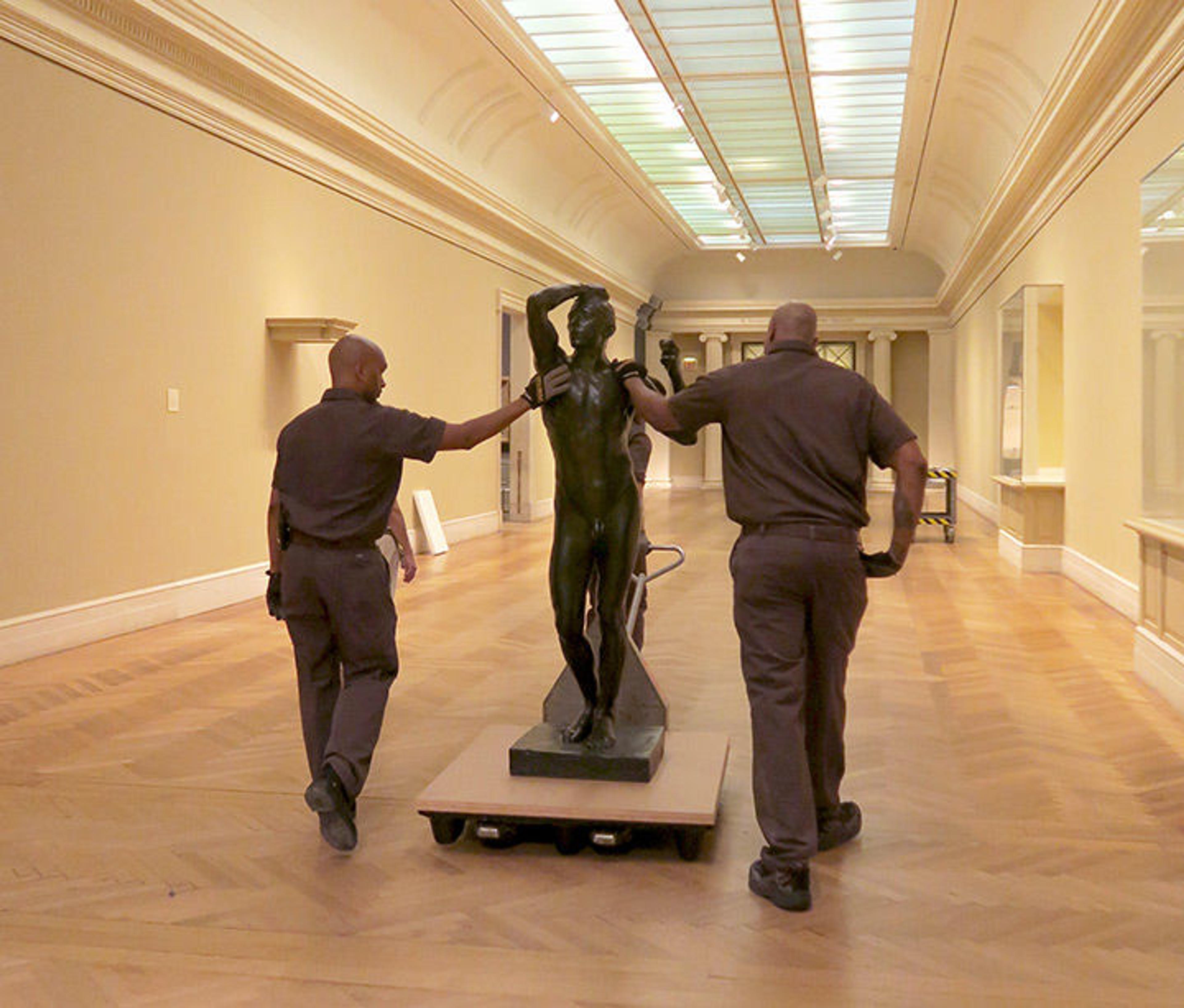 The Age of Bronze making its exit with Museum riggers (responsible for moving large-scale artworks) Lionel Carre (left) and Derrick Williams (right).