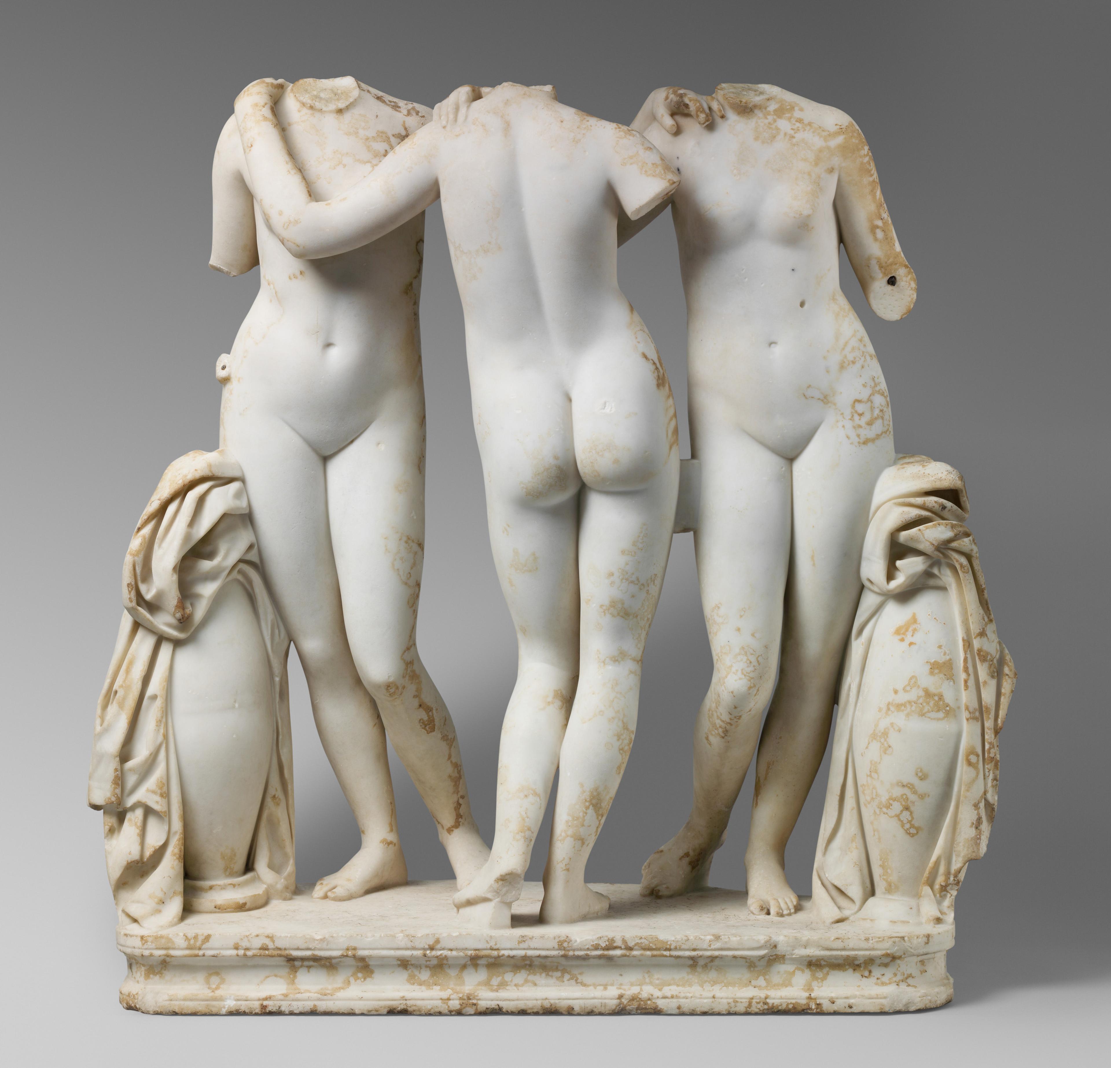 Sculpture of three young nude women linked in a dance-like pose.