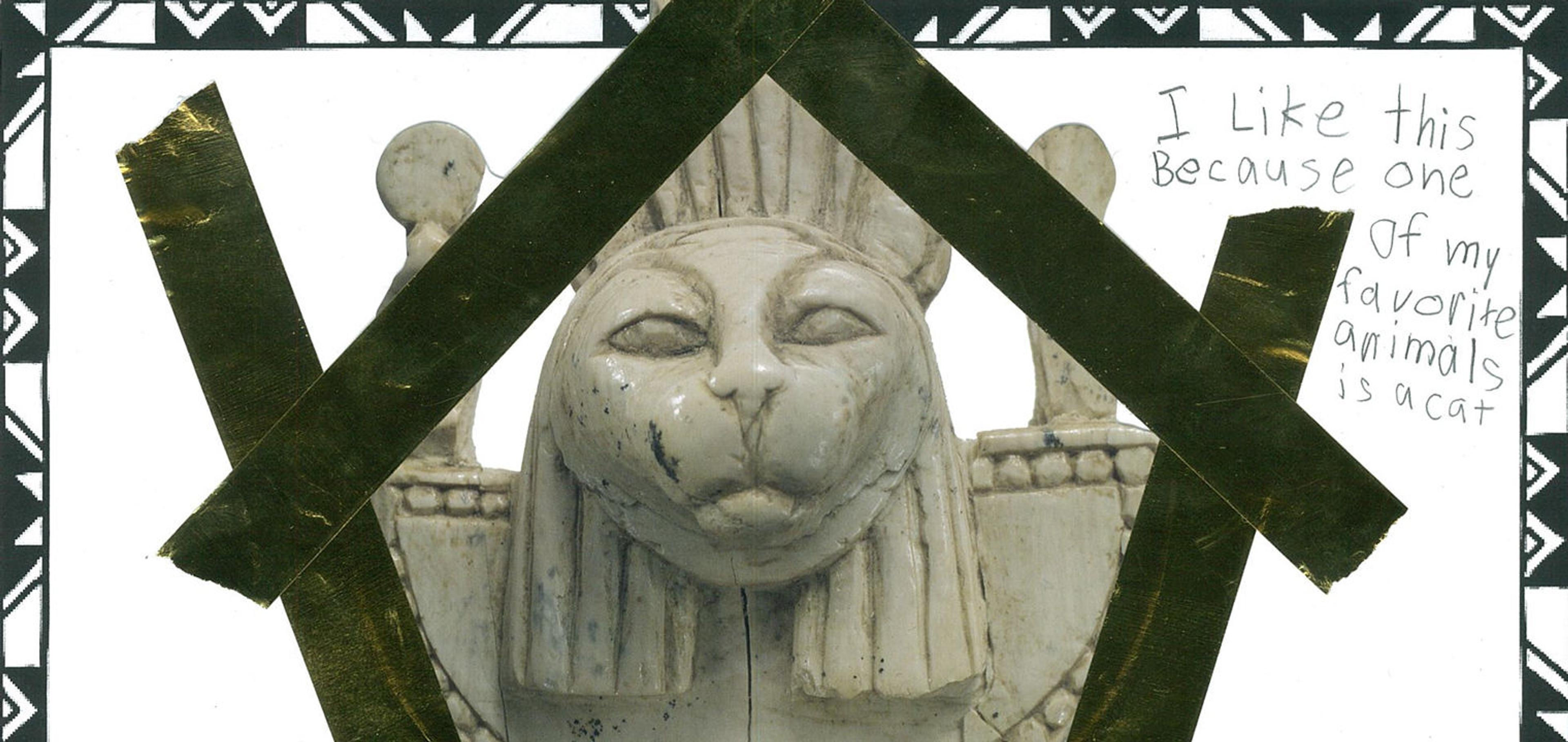 Picture of a kid's love letter to an ivory carving with a sculpted cat head wearing a collar. The kid has decorated the love note with gold tape.