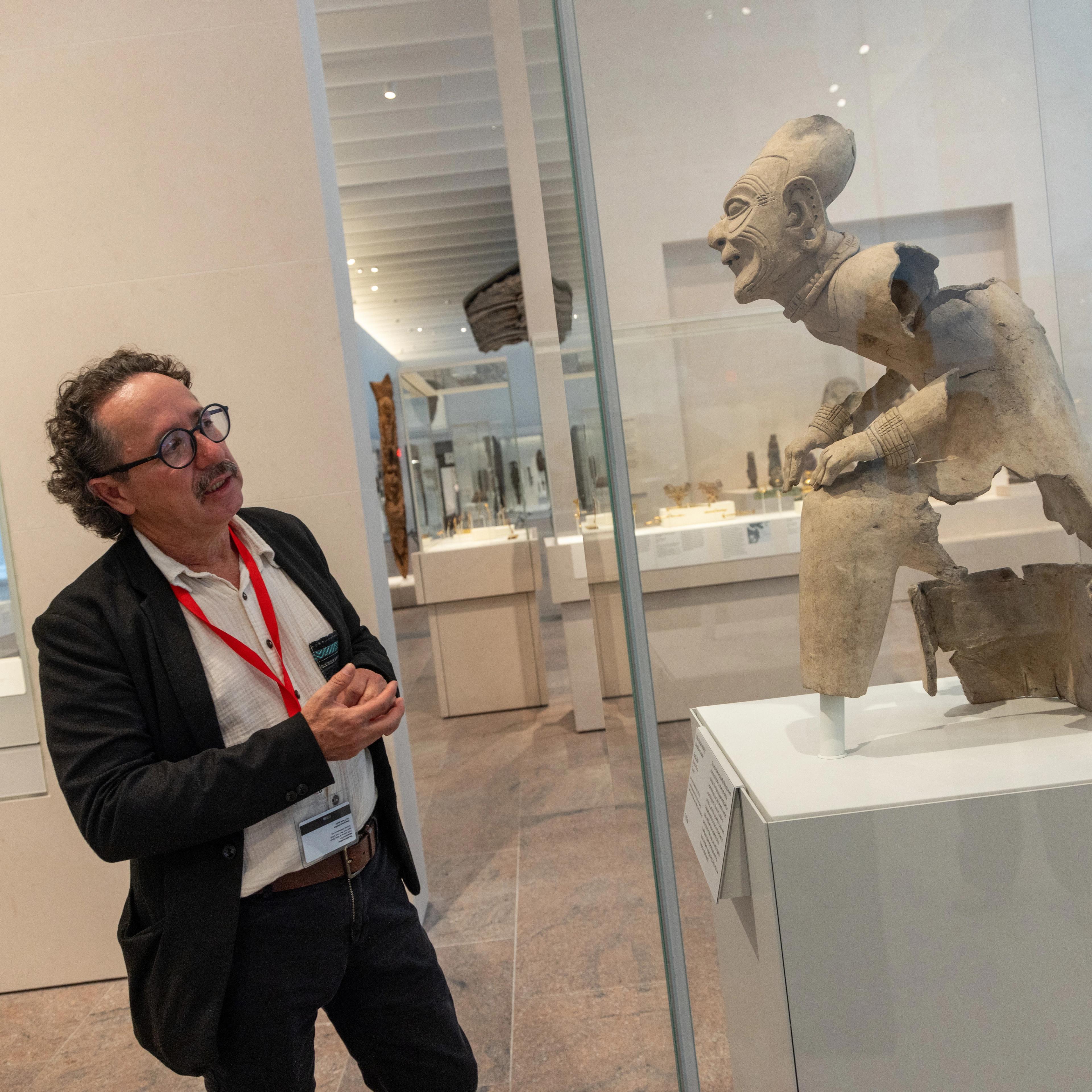 Florencio Delgado Espinoza gazes at the seated elder statue in the Arts of the Ancient Americas galleries.