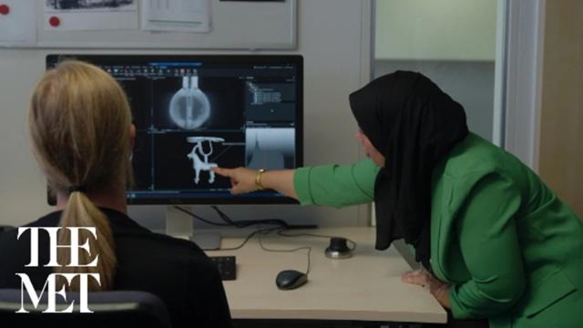 A woman points at an x ray on a screen