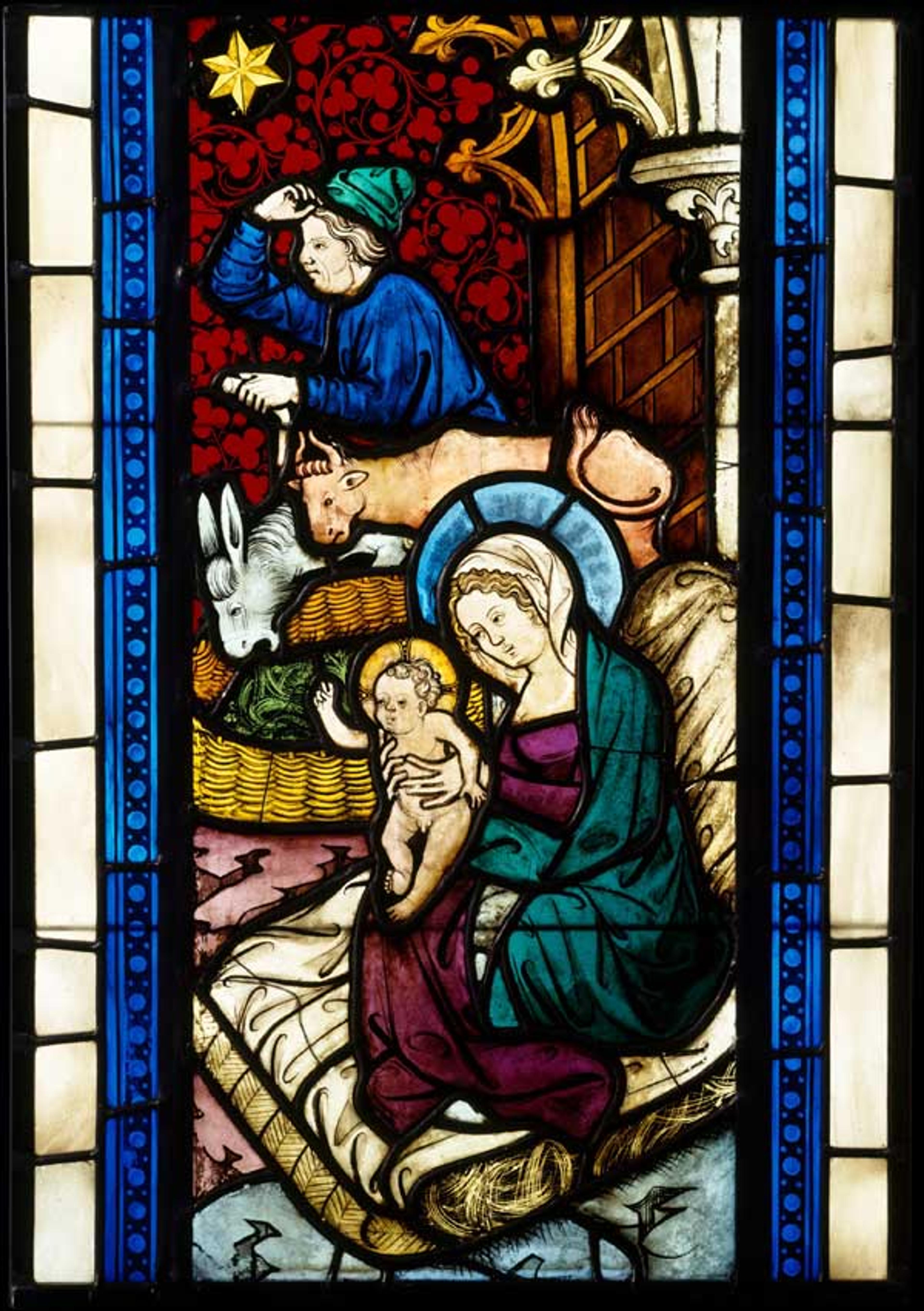 Note the circular wattle fence used to contain the fodder for the ox and ass. Adoration of the Magi from Seven Scenes from the Life of Christ (detail), ca. 1390. Made in Lower Austria. Pot-metal and colorless glass, vitreous paint and silver stain; H. 27 5/16 x 12 15/16 in. (69.4 x 32.8 cm). The Metropolitan Museum of Art, The Cloisters Collection, 1986 (1986.285.2)
