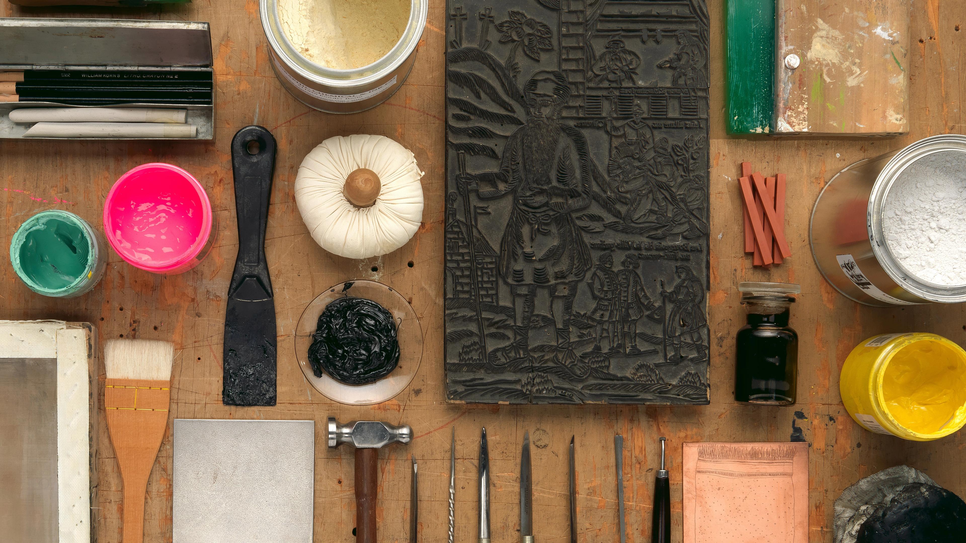 An artful arrangement of printmaking tools laid out on a table.