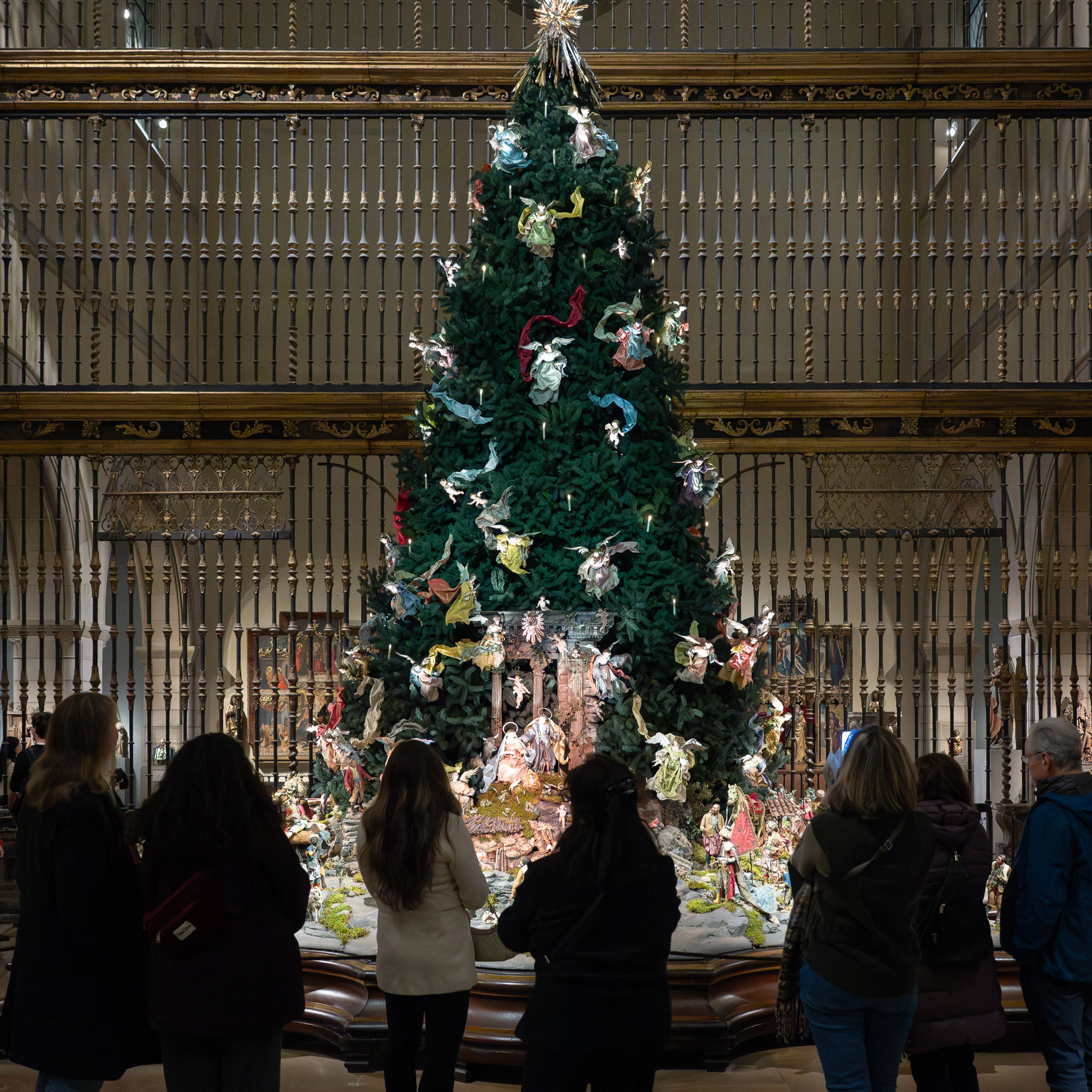 A group of visitors look at the Christmas Tree and Neapolitan Baroque Crèche at The Met.