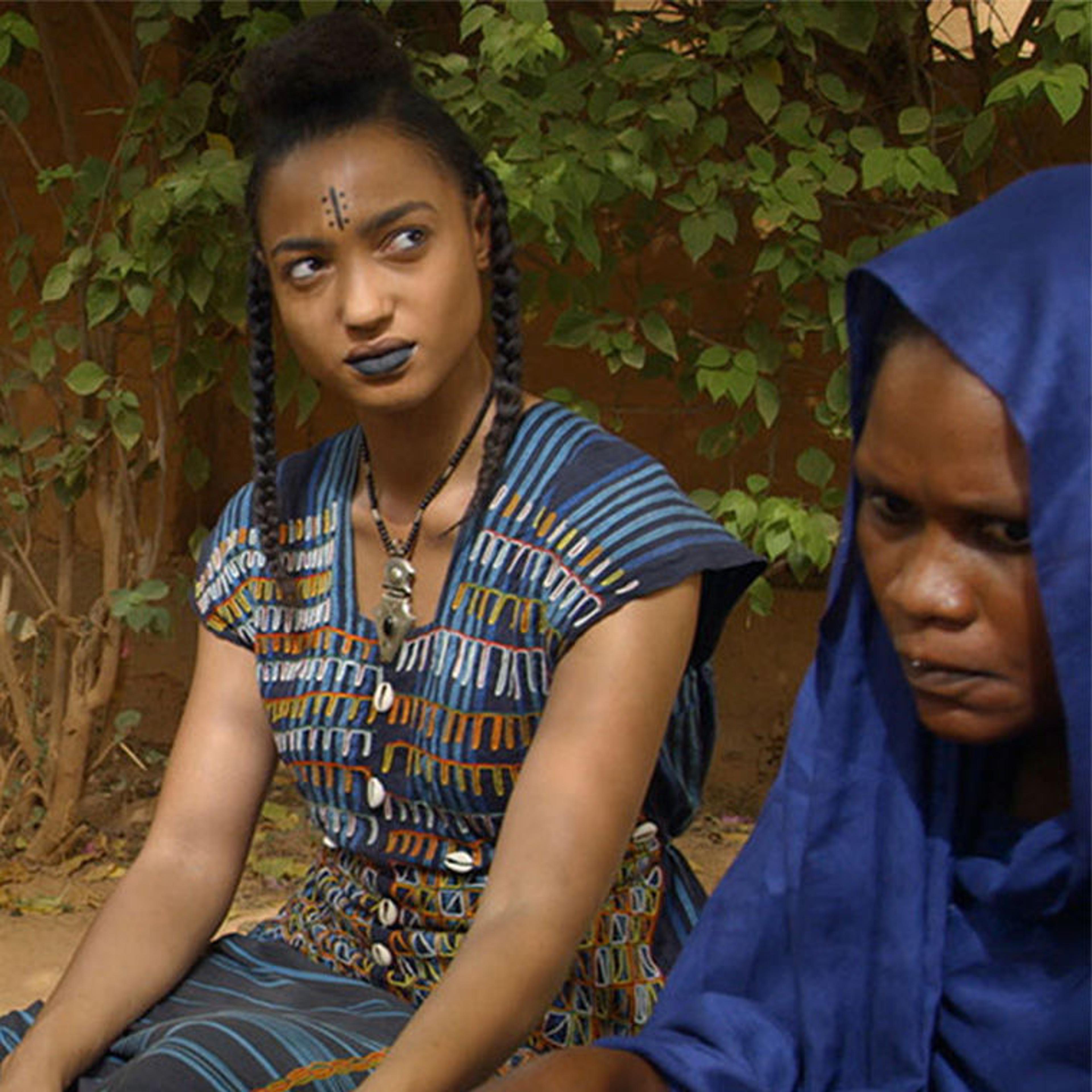 Four women are seated around a bowl, looking upward toward the light