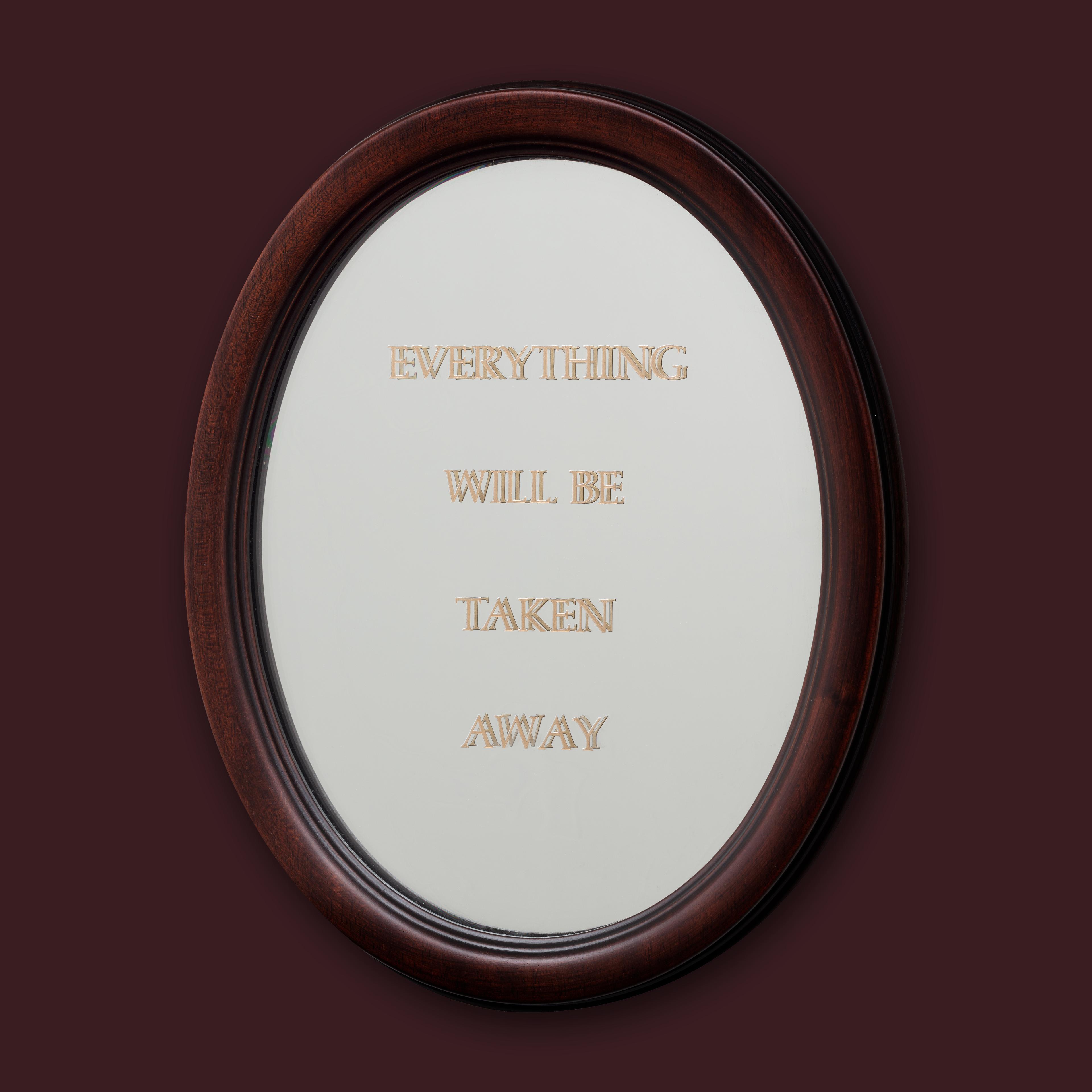 Brown backdrop with an oval mirror in the center that reads " Everything Will Be Taken Away" in capital letters. 