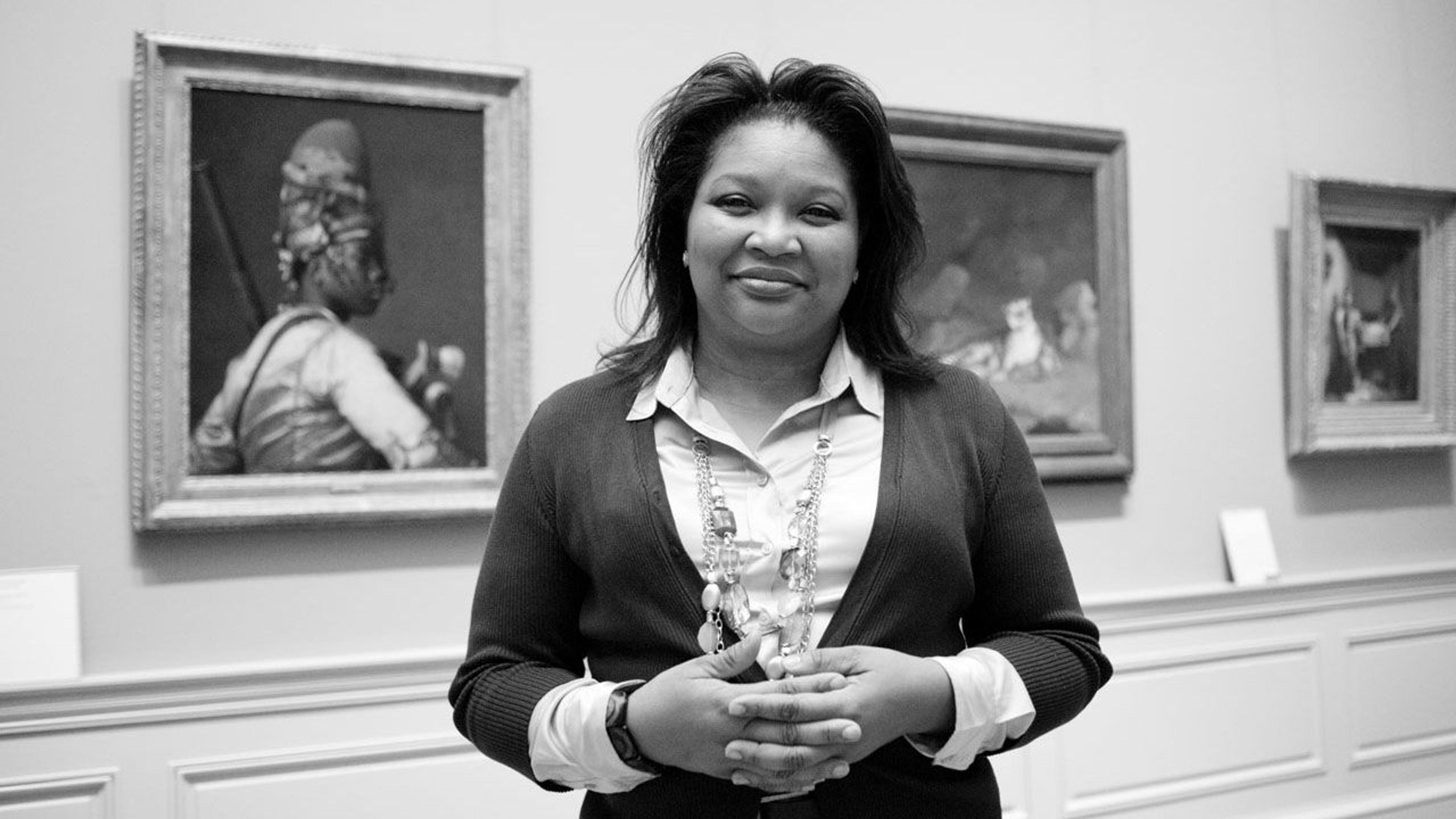 Black and white photograph of art preparator Theresa King-Dickinson standing in a paintings gallery at The Met