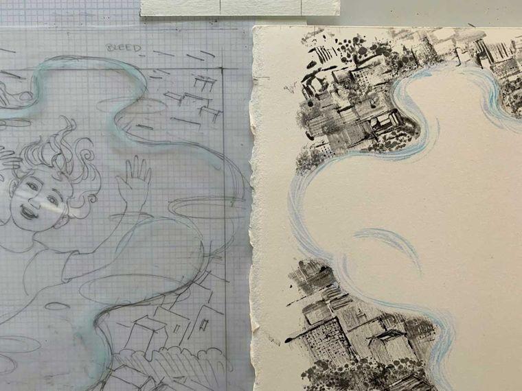 On the left, a pencil sketch of a girl floating through the sky above a cloud with a cityscape pattern on the upper right corner with blue cloud like lines drawn around the image in ink.. To the right is a white sheet of paper with the ink of the cityscape and cloud pattern transferred onto it.