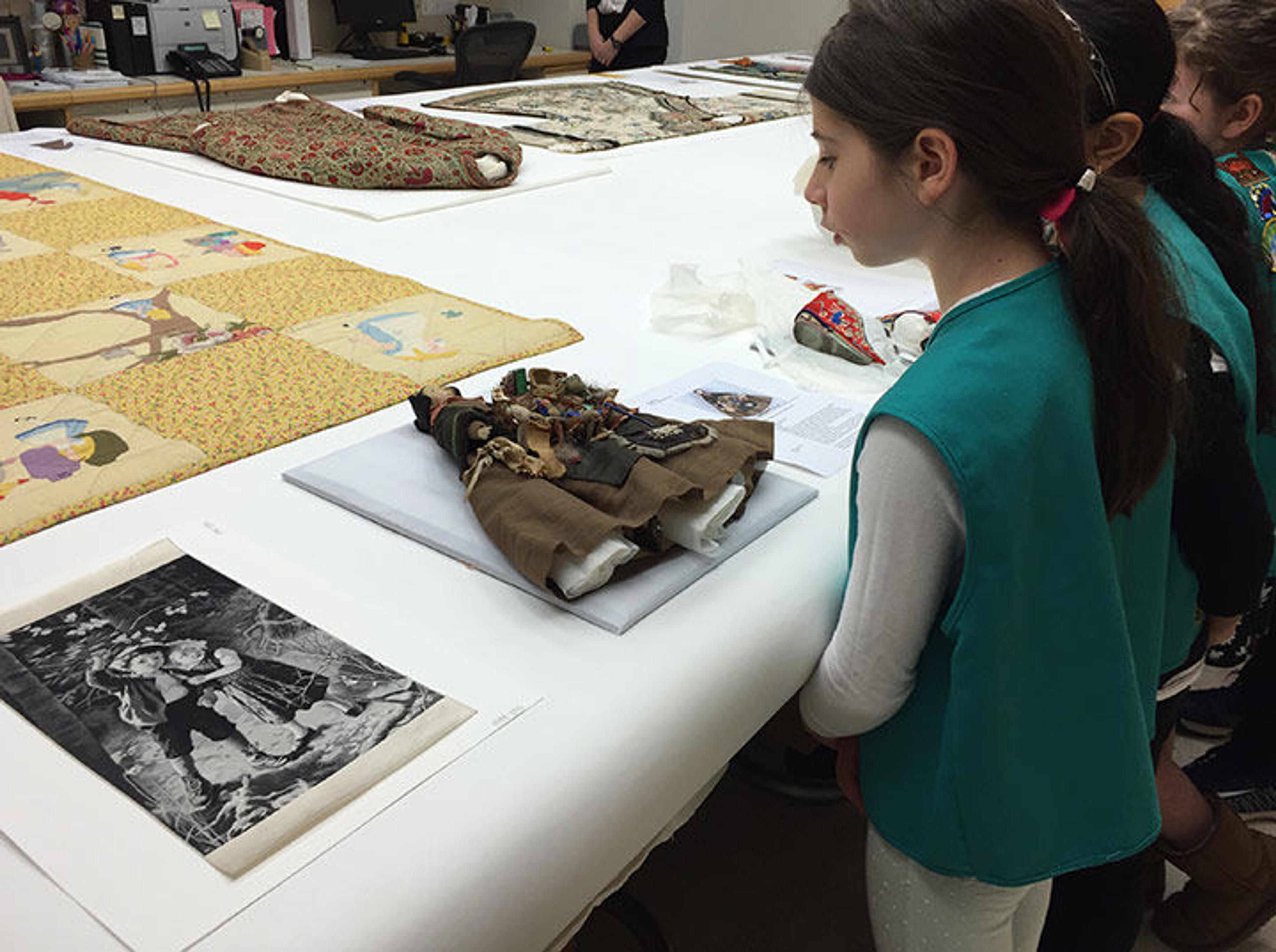 A girl looks at a doll