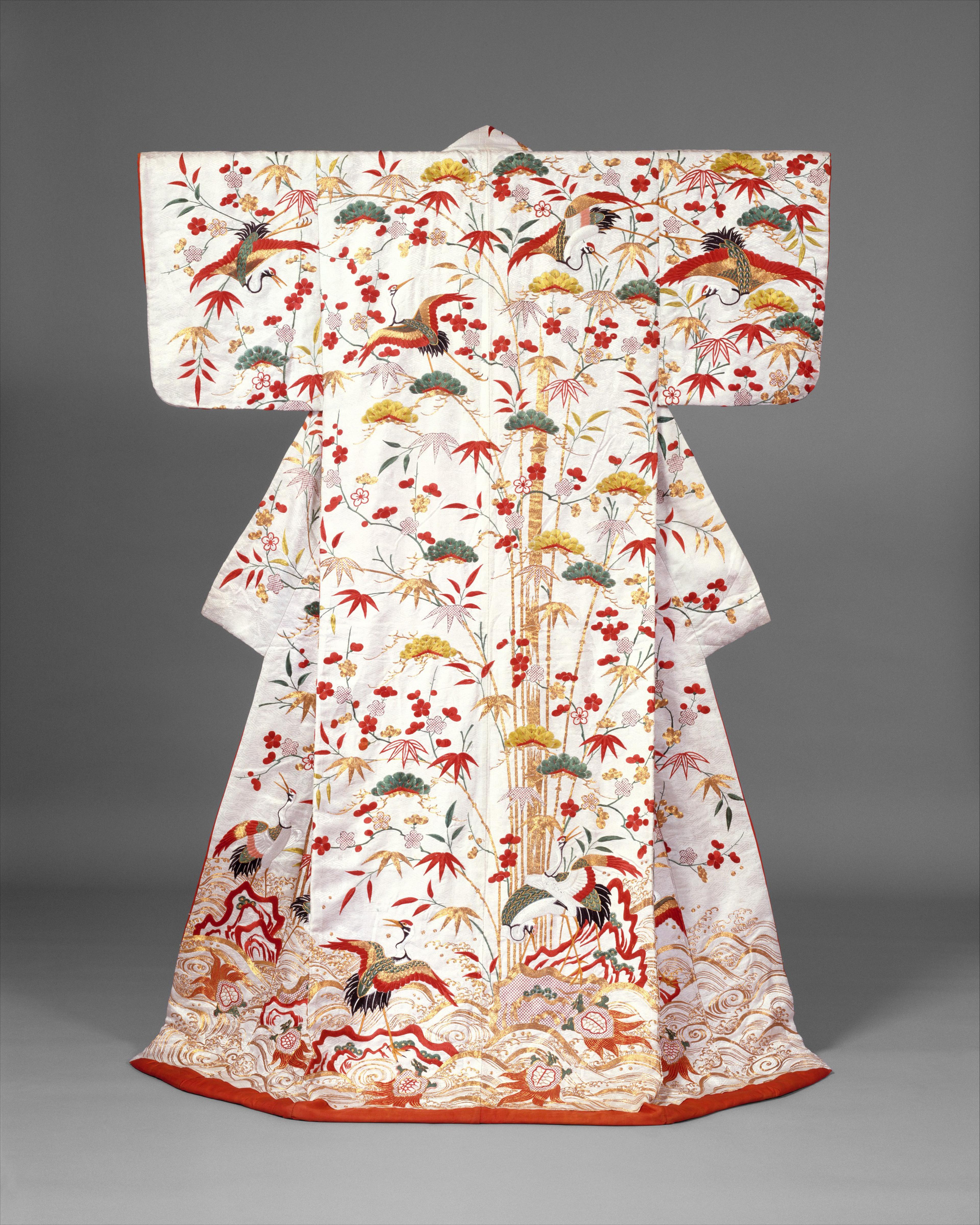 A white Japanese robe elaborately decorated with red, gold, green and black embroidery of cranes, tortoises, and bamboo.