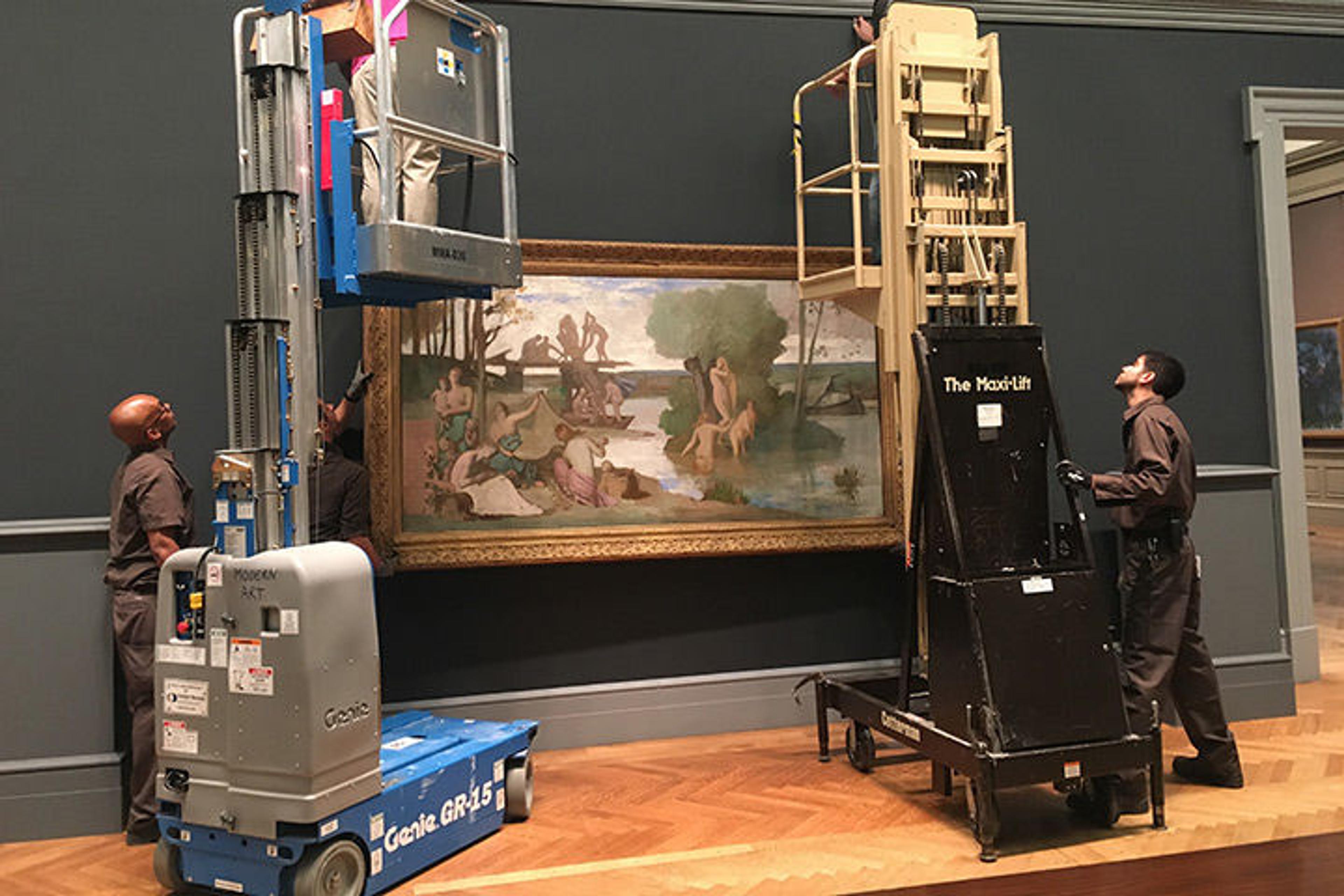 Excitement builds as art begins to repopulate the gallery. Here, painting technicians and riggers install a painting called The River by Rodin's friend Puvis de Chavannes on the gallery's south wall