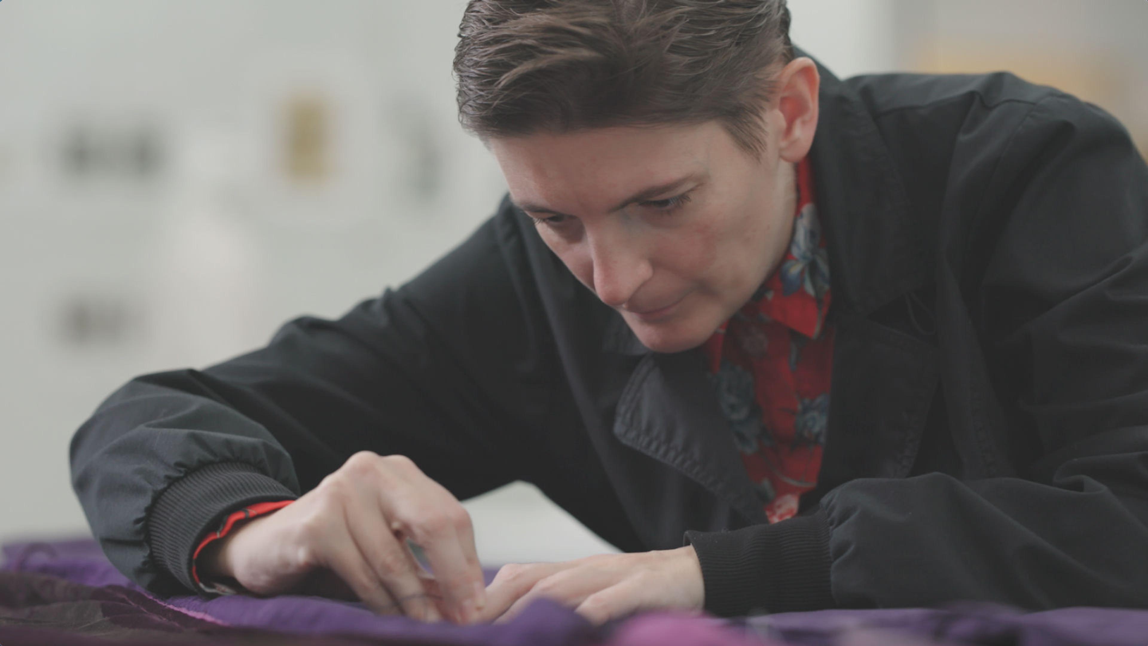 Associate Conservator Melina Plottu works on the conservation of purple silk dress