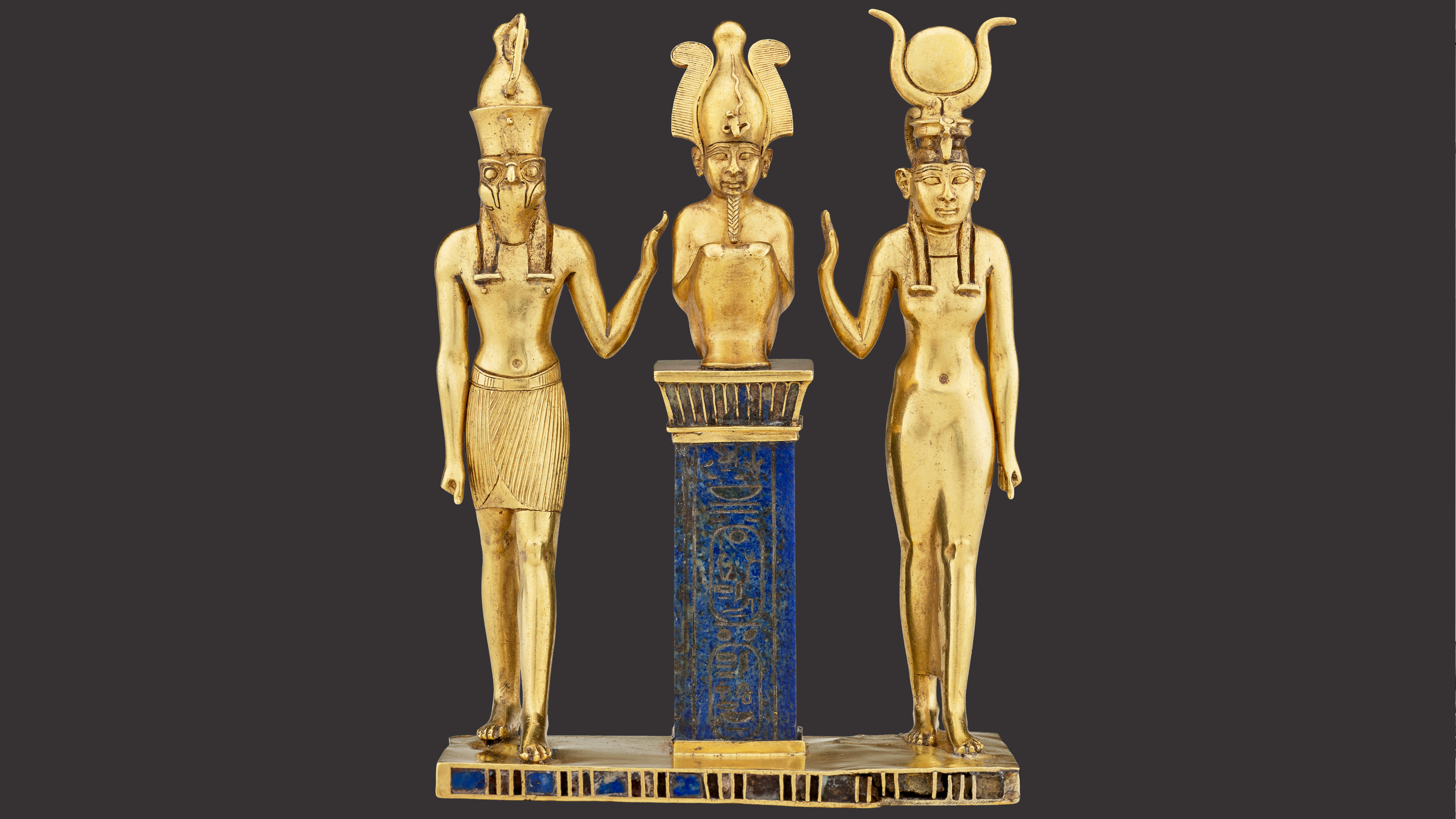 Triad of Osiris, Horus, and Isis. From Egypt, probably Thebes, Karnak Temple. Third Intermediate Period, Dynasty 22, reign of Osorkon II (about 872–837 BCE). Gold inlaid with lapis lazuli. Acquired in 1872. Paris, Louvre Museum, Department of Egyptian Antiquities (E 6204). © 2025 GrandPalaisRmn (Louvre Museum). Photo by Mathieu Rabea