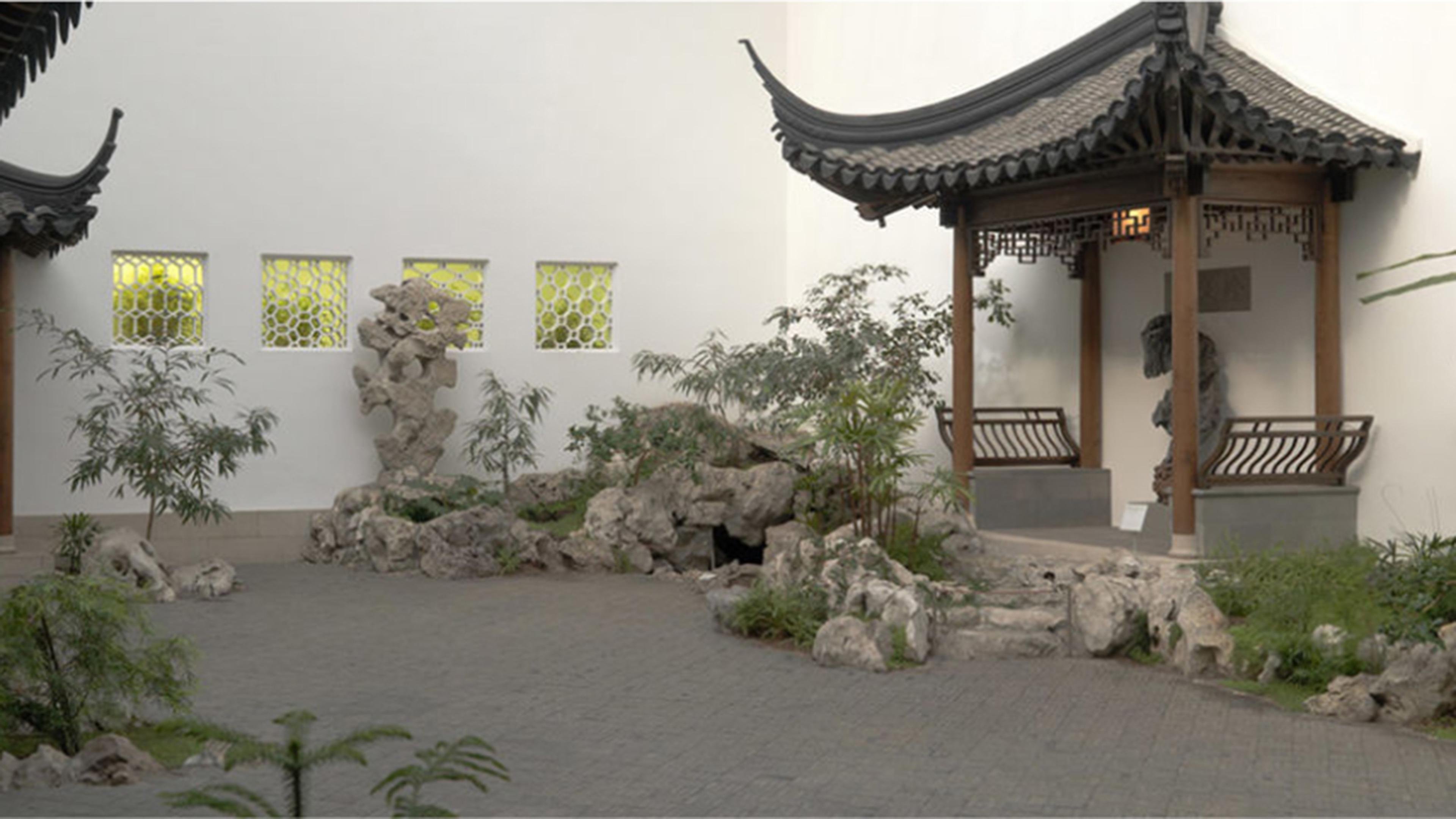 An interior courtyard with pagodas, plantings, ornamental rocks, and a fish pond