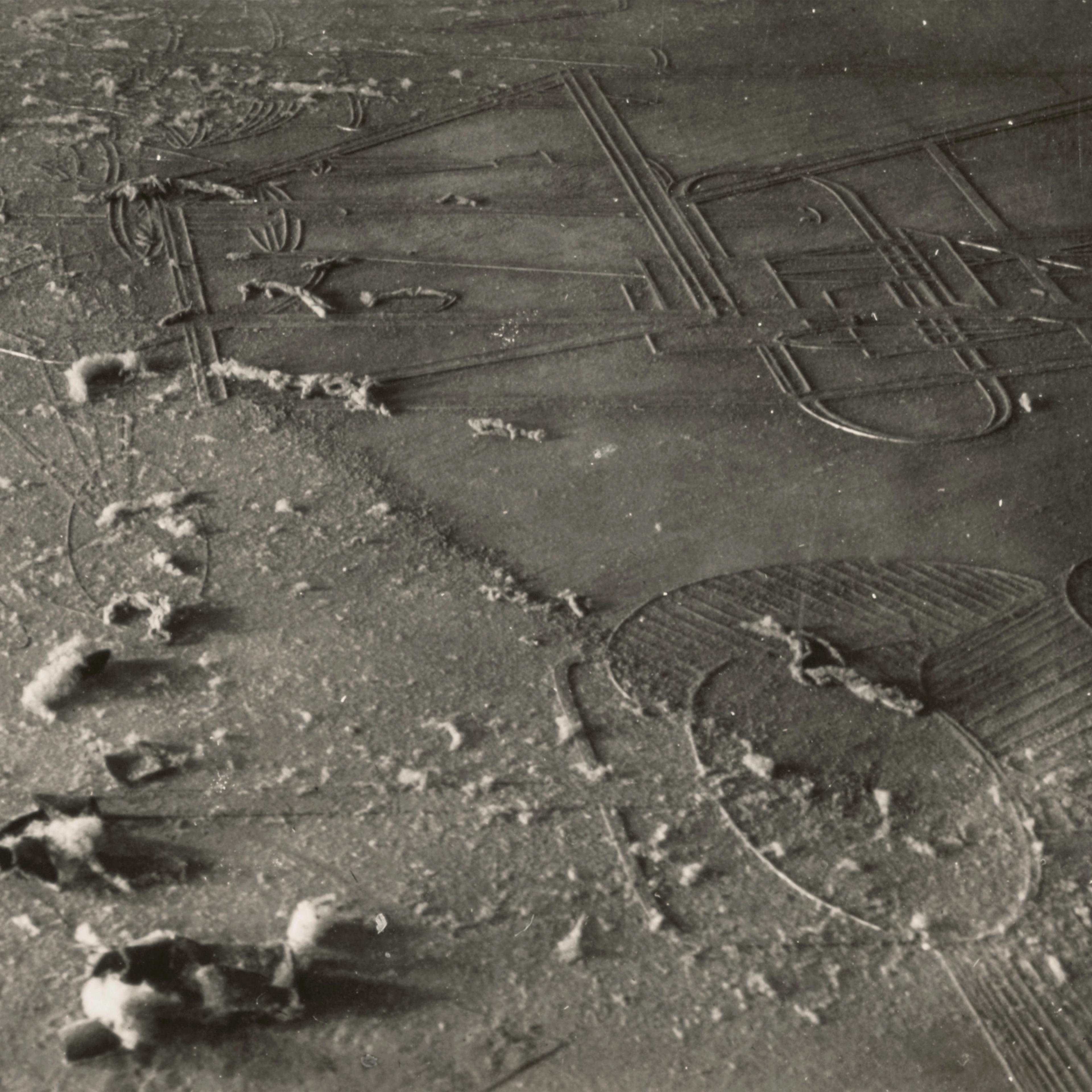 Dusty floor with intricate geometric patterns partially covered by a thin layer of dust. Soft footprints disrupt the dust, adding texture and intrigue.