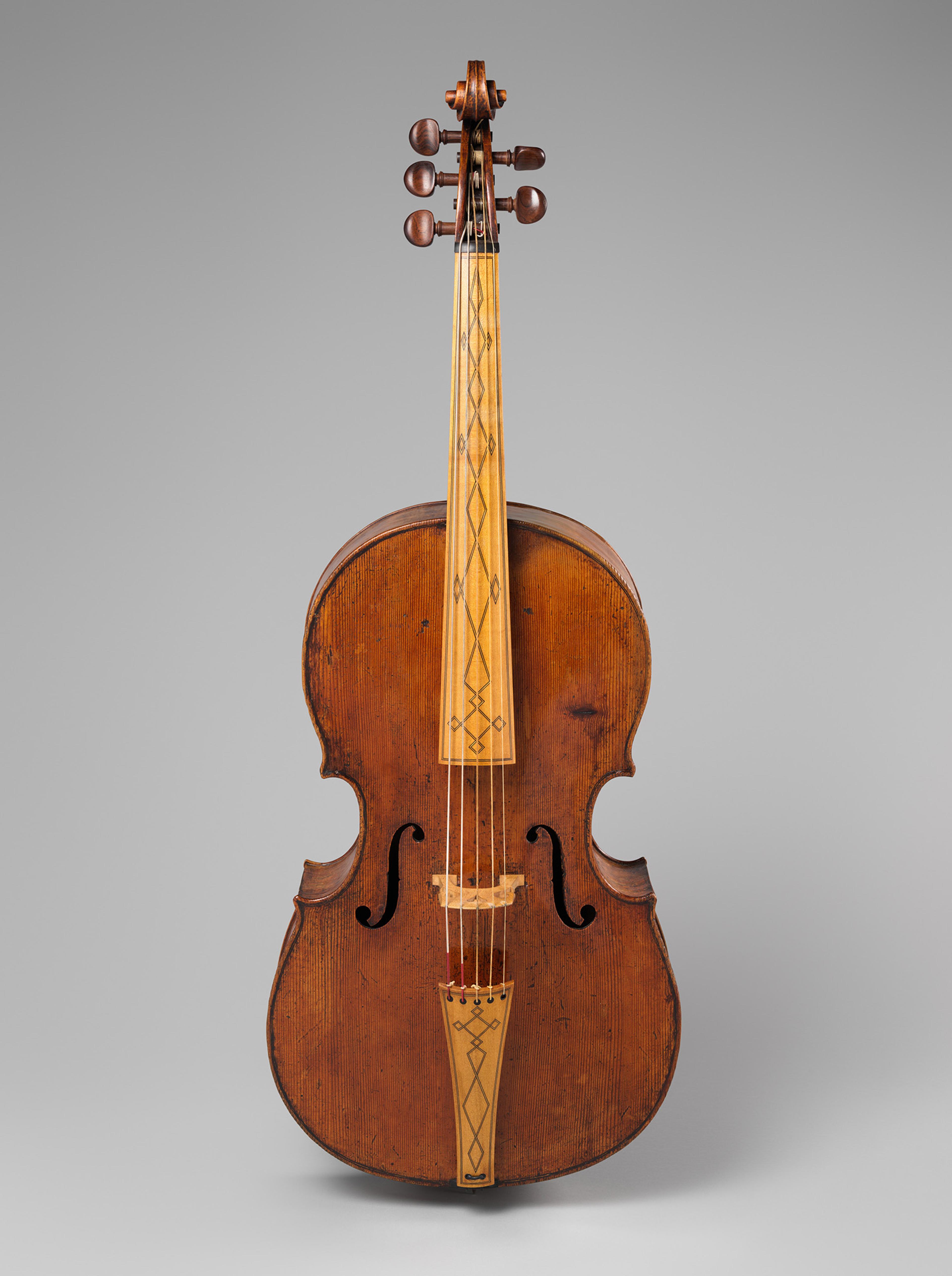A vintage string instrument with a warm, reddish-brown wood finish, intricate neck design, and curvy body. Tone is elegant and timeless.