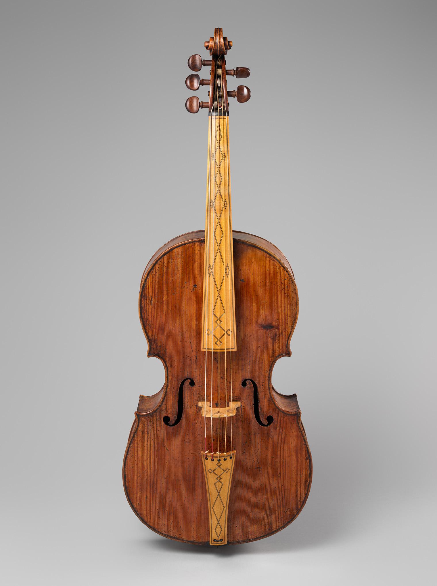 A vintage string instrument with a warm, reddish-brown wood finish, intricate neck design, and curvy body. Tone is elegant and timeless.