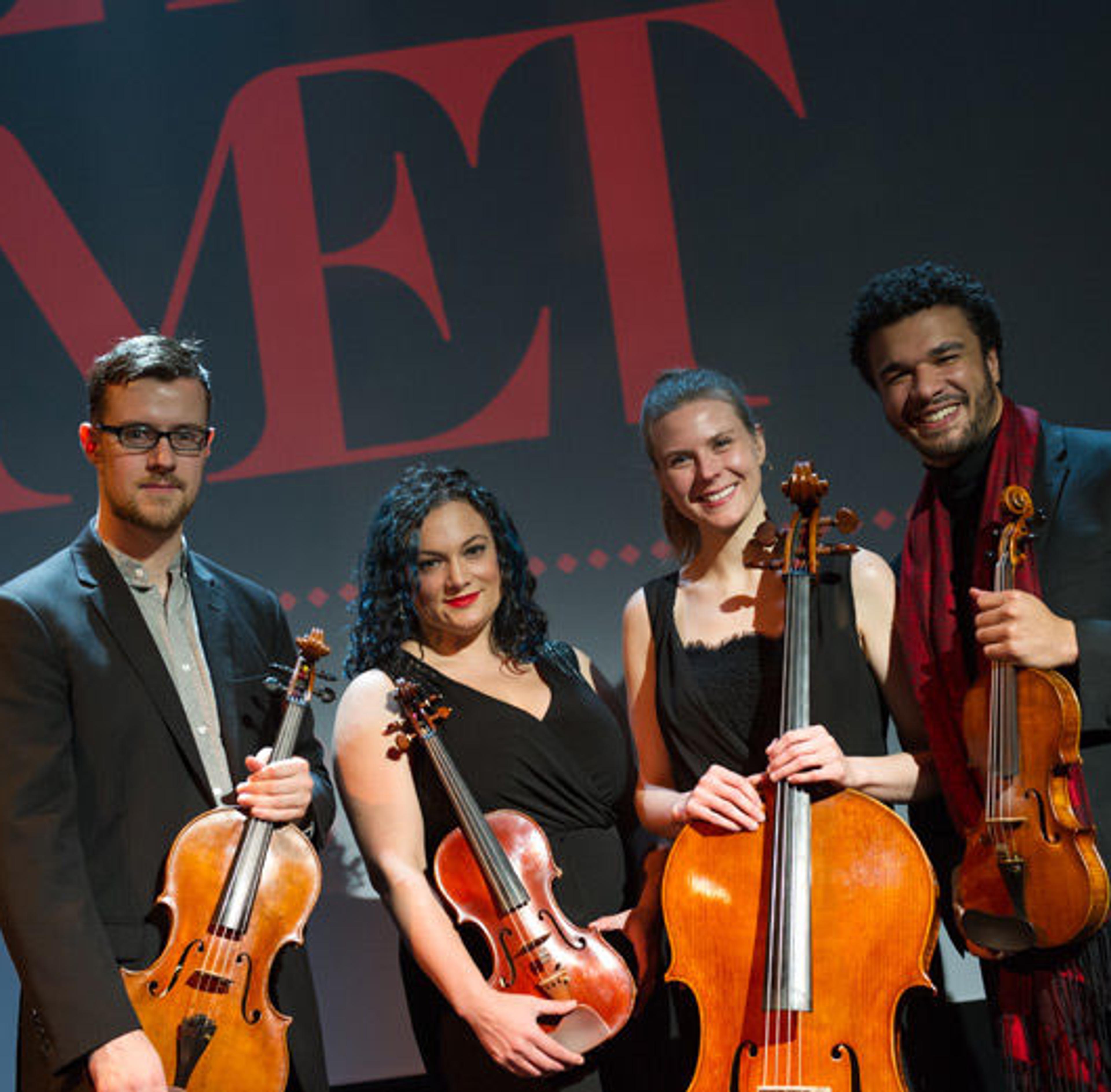 Four members of a string quartet pose with their instruments