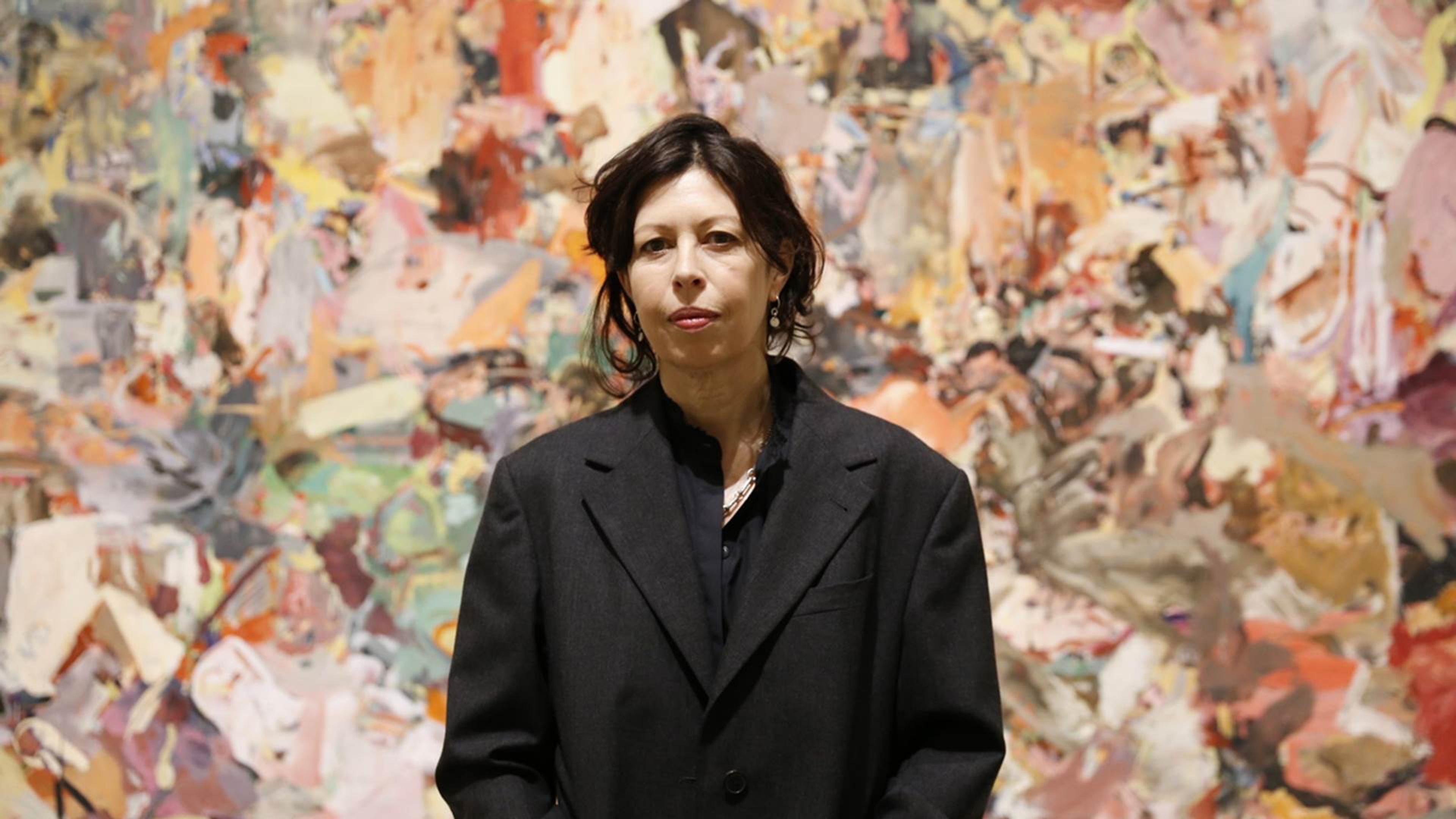 Portrait of artist Cecily Brown in front of her vibrant painting "Carnival and Lent" (2006-2008)