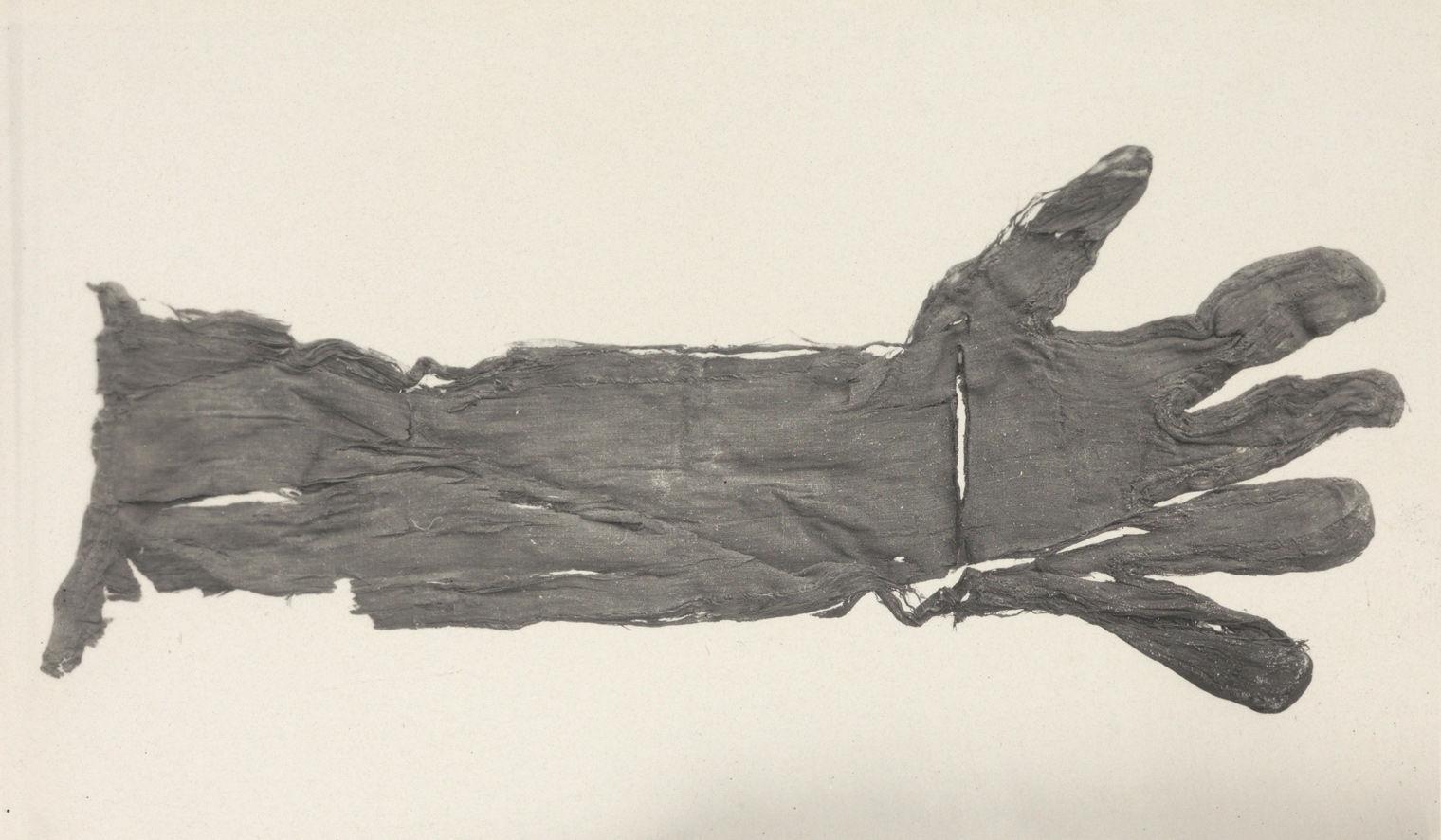 Black and white image of a small elbow-length glove with fingers spread out.