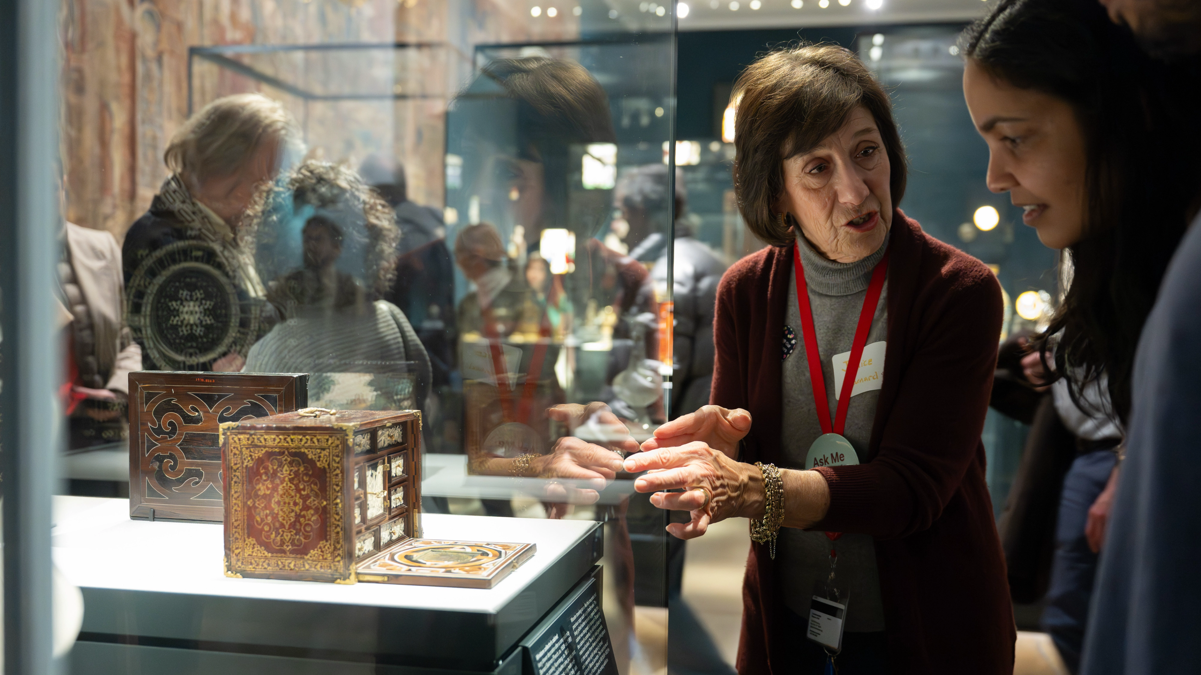 A tour guide and a visitor looking at art. 
