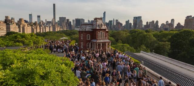 Visitors on the Roof Garden, lush trees and landscaping surrounds them.