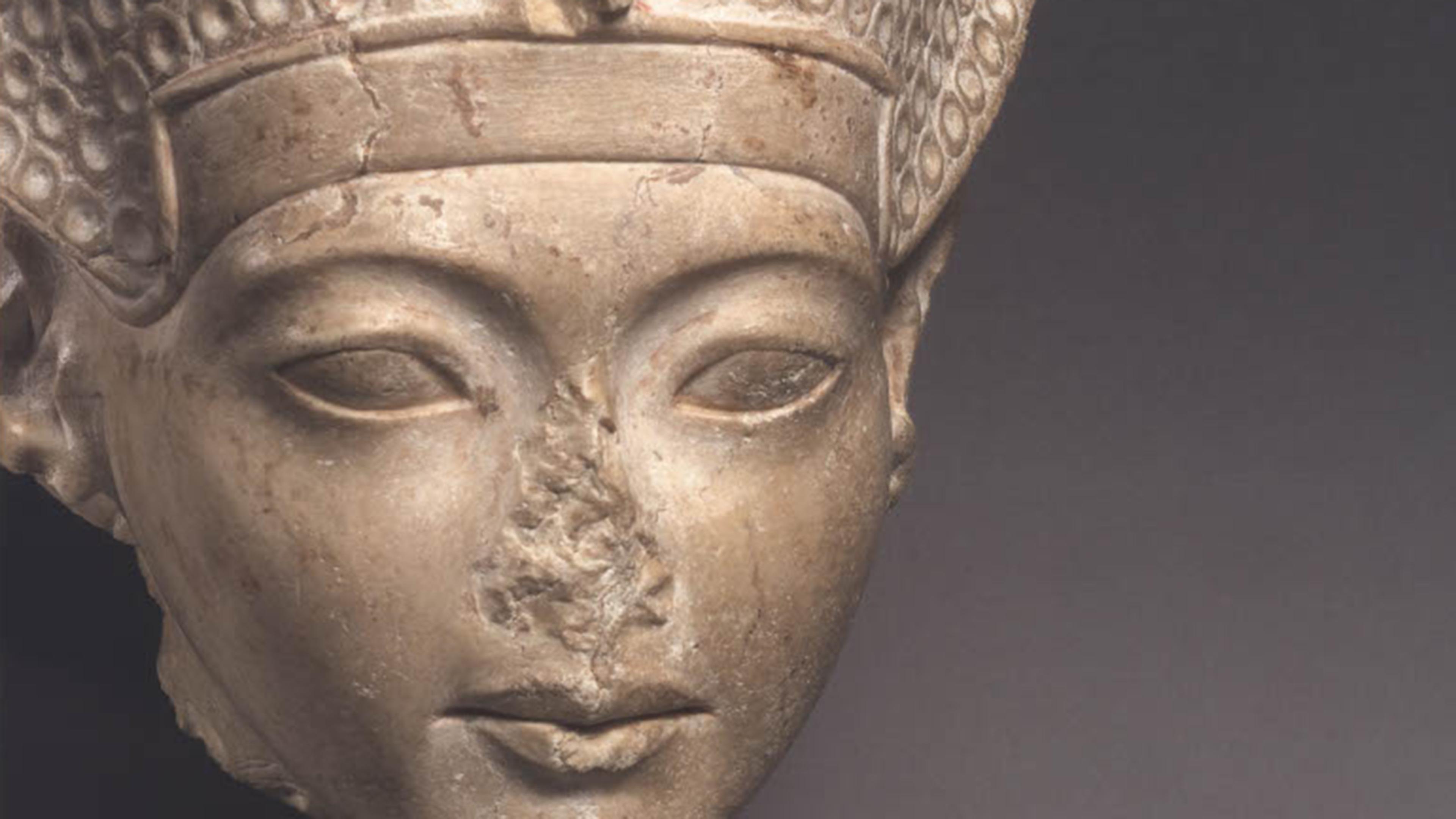 Close up of limestone head with missing nose.