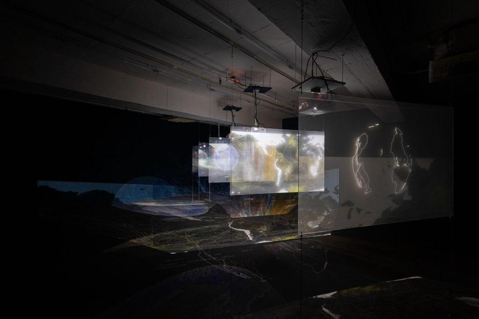 Installation view of Sean Connelly's Africa-Pacific, showing multiple glowing projectors