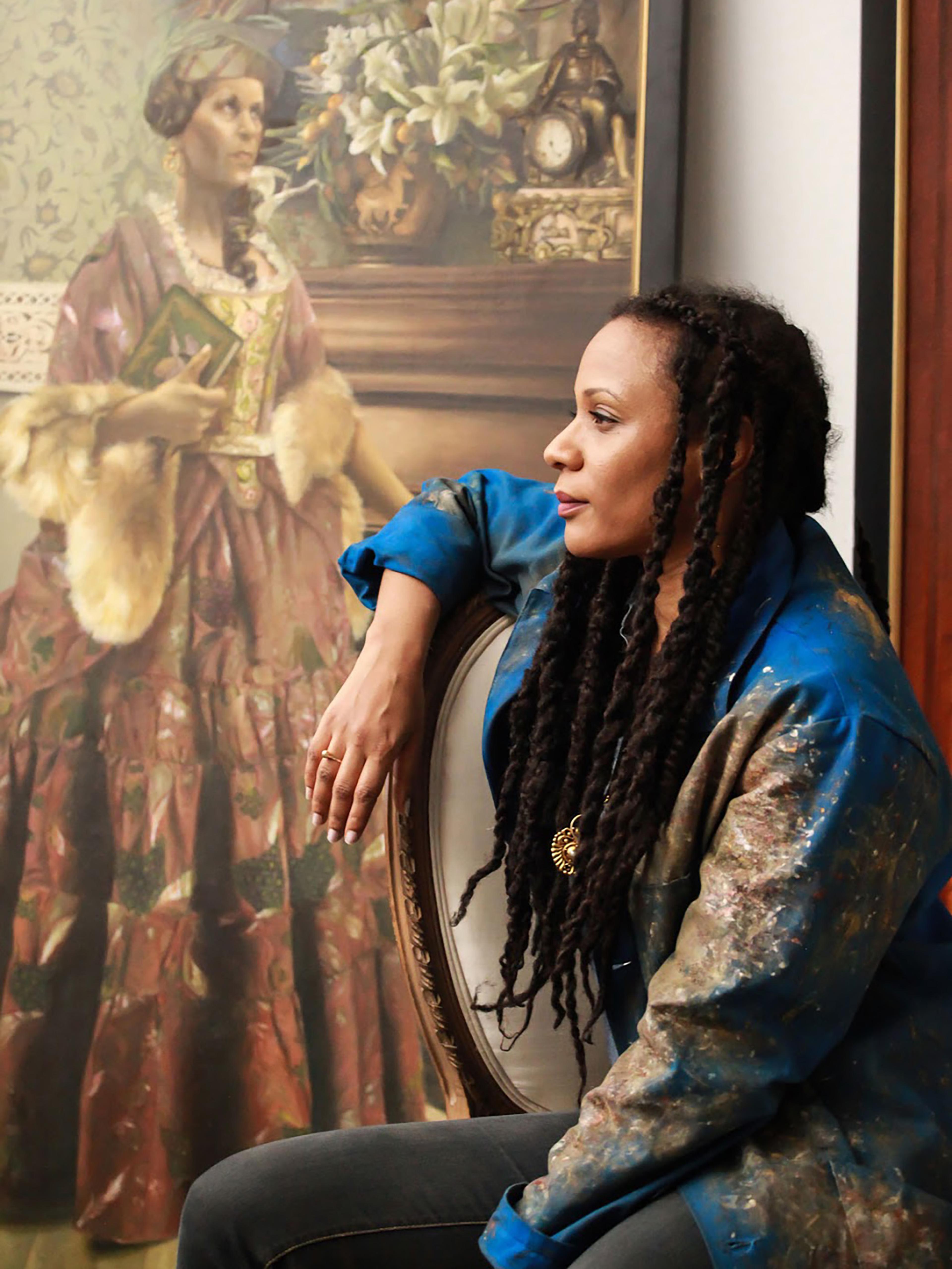 Artist Elizabeth Colomba posing with one of her paintings.