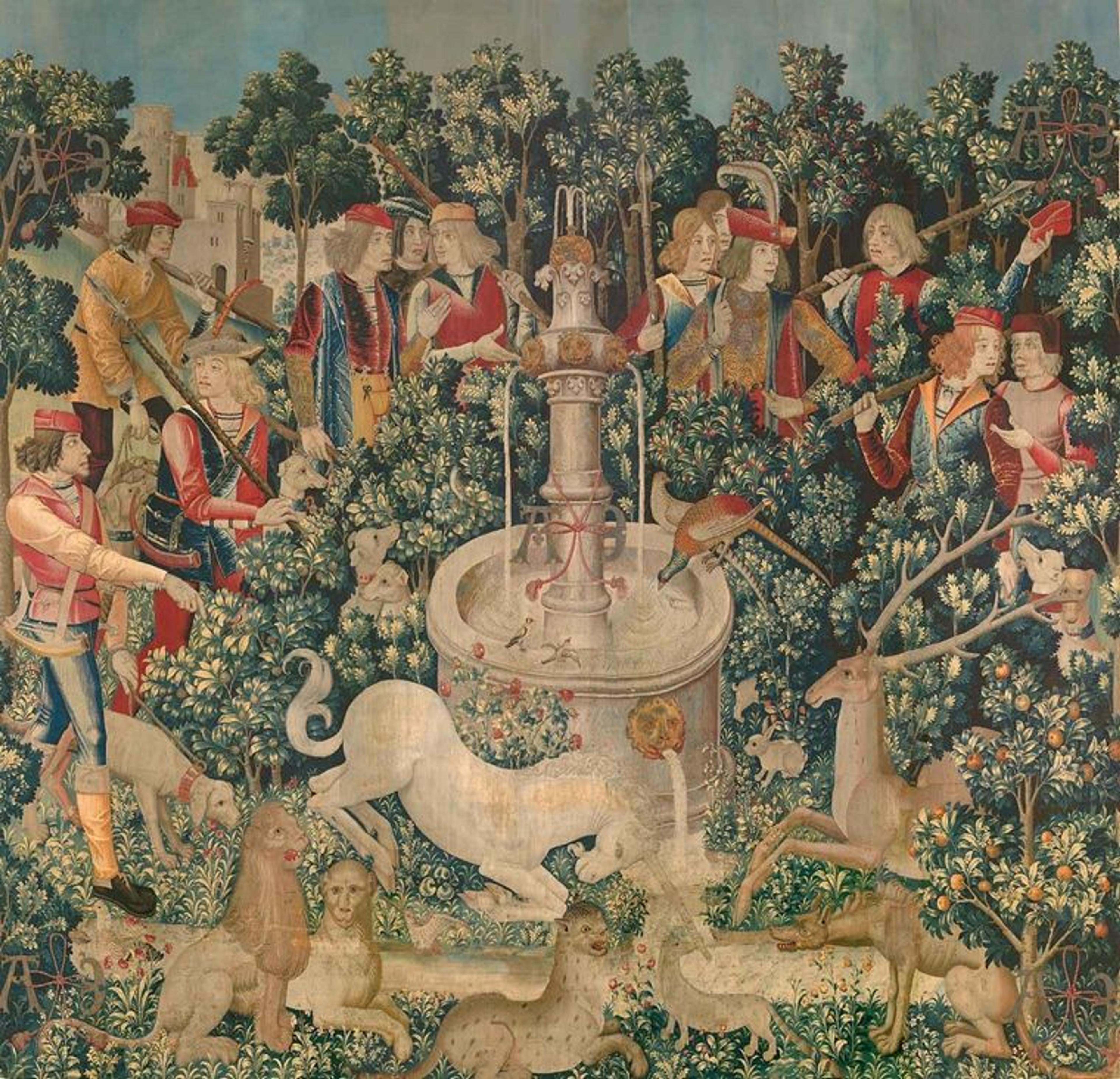 In this medieval tapestry, a unicorn dips its horn into a stream beneath a fountain. It is surrounded by animals to its left and right, and a dozen hunters standing in a semi circle behind it. 