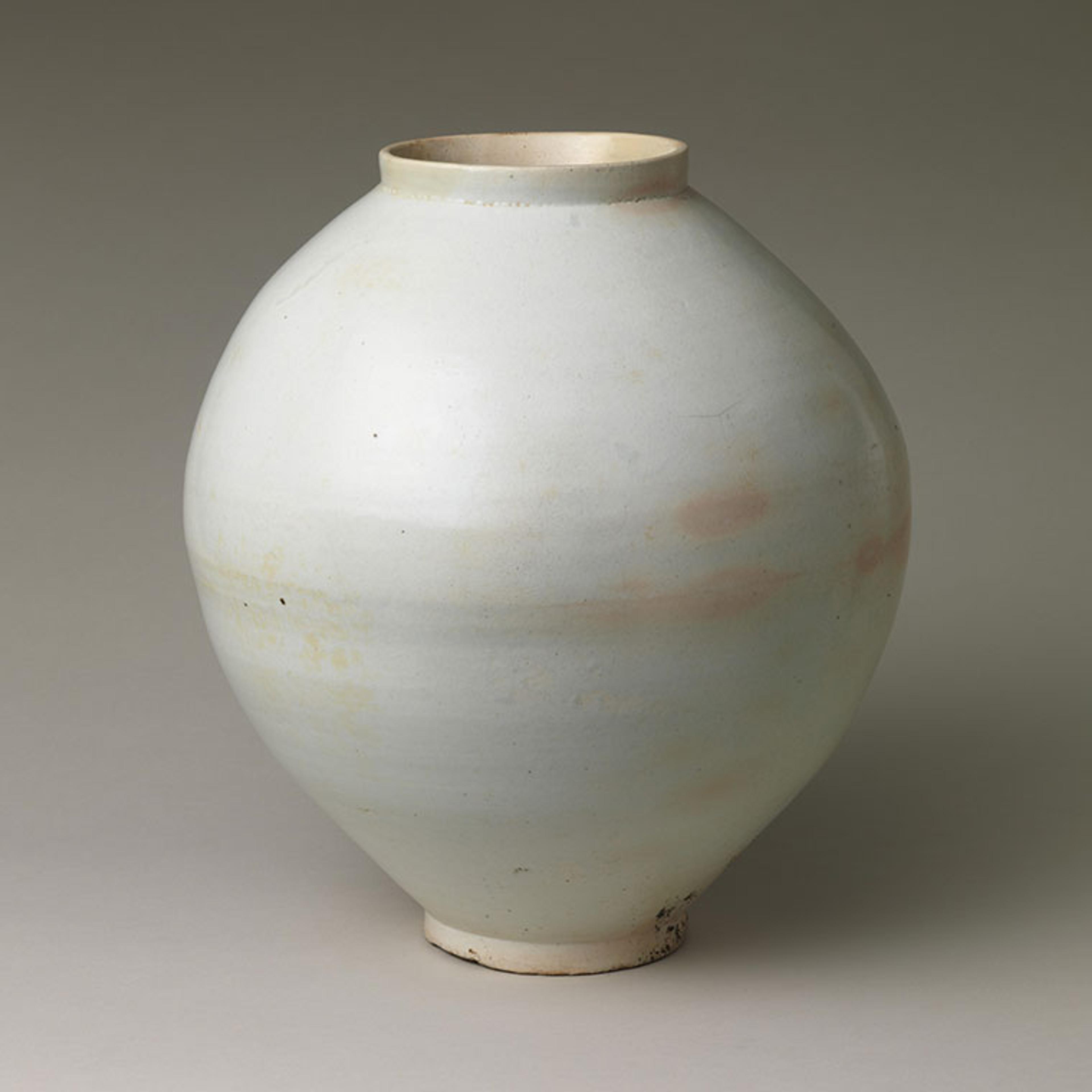 A large, white jar with some peach colored spots around the center