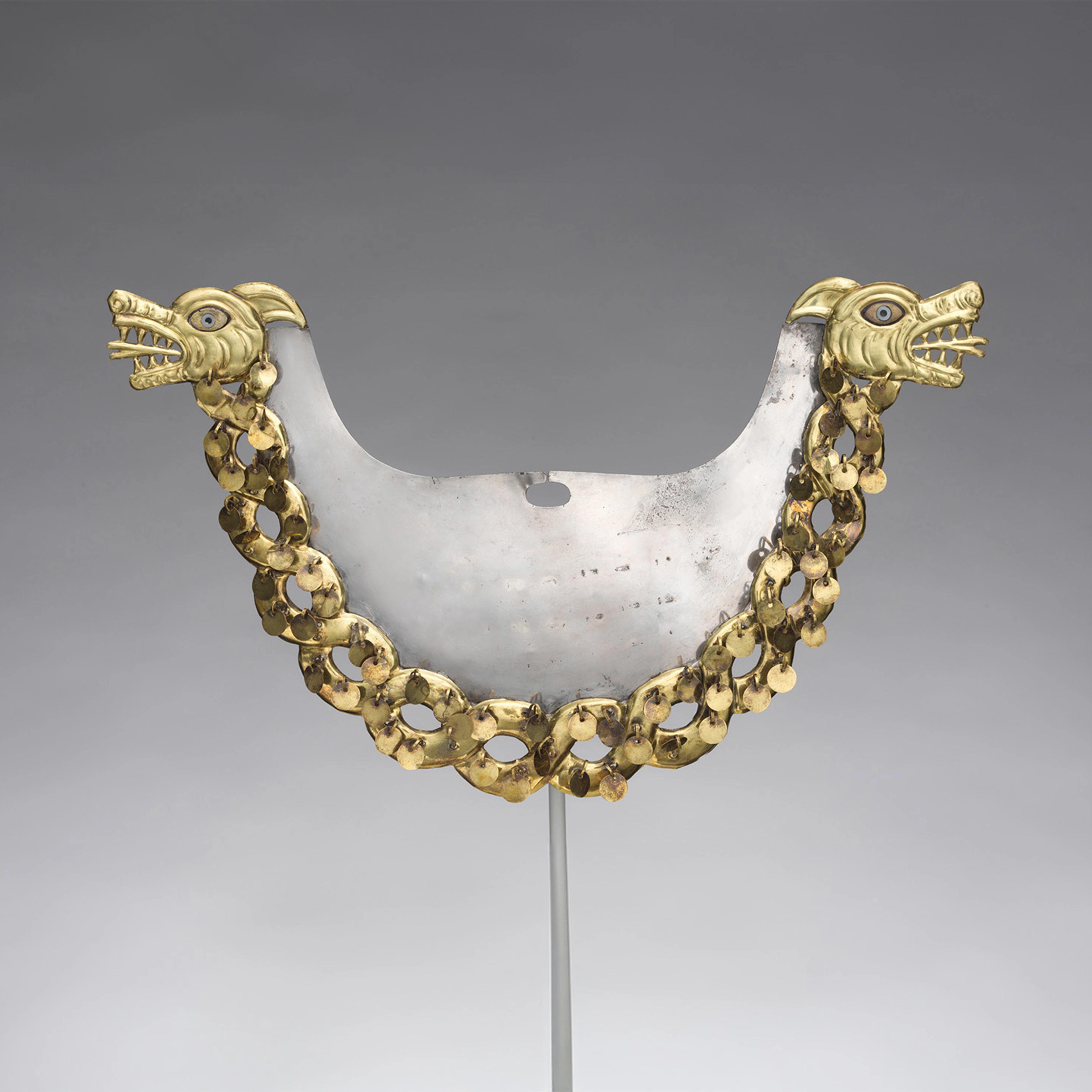 An ornate metal breastplate with two dragon heads, detailed with gold and blue accents. Connected by a chain of gold links