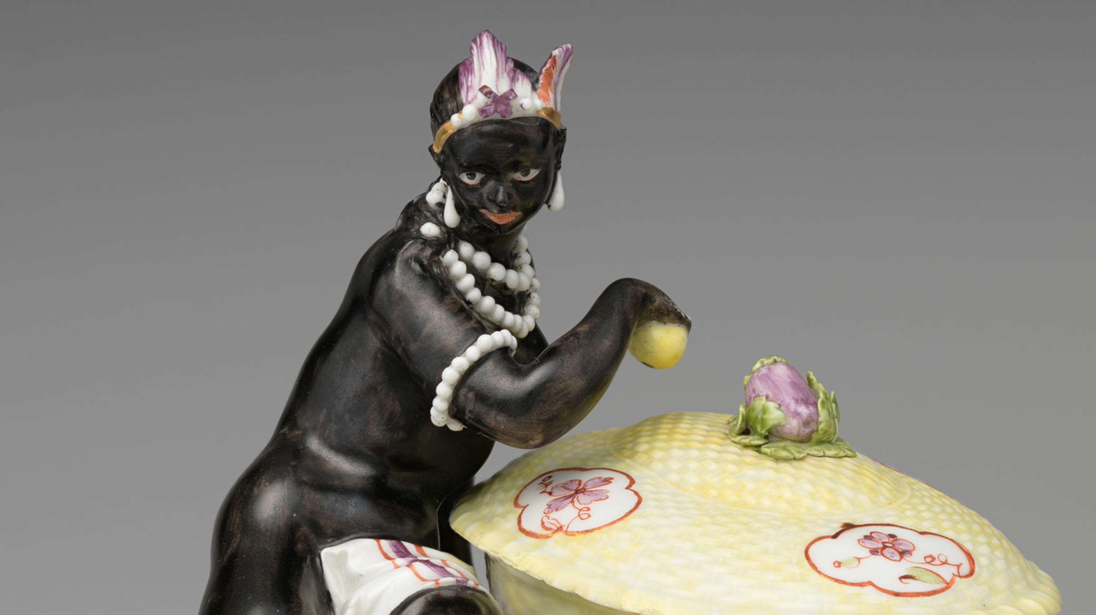 A pair of black men with feathers decorating their heads and body next to a cup covered with a lid