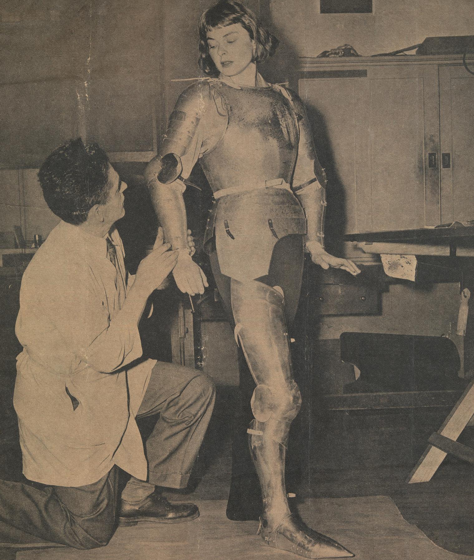 Leonard Heinrich fabricating and fitting a suit of armor on Ingrid Bergman which she wore in the title role of the 1948 film Joan of Arc.