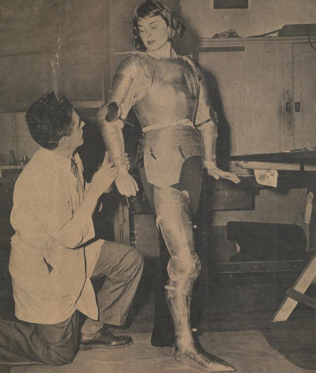 Leonard Heinrich fabricating and fitting a suit of armor on Ingrid Bergman which she wore in the title role of the 1948 film Joan of Arc.