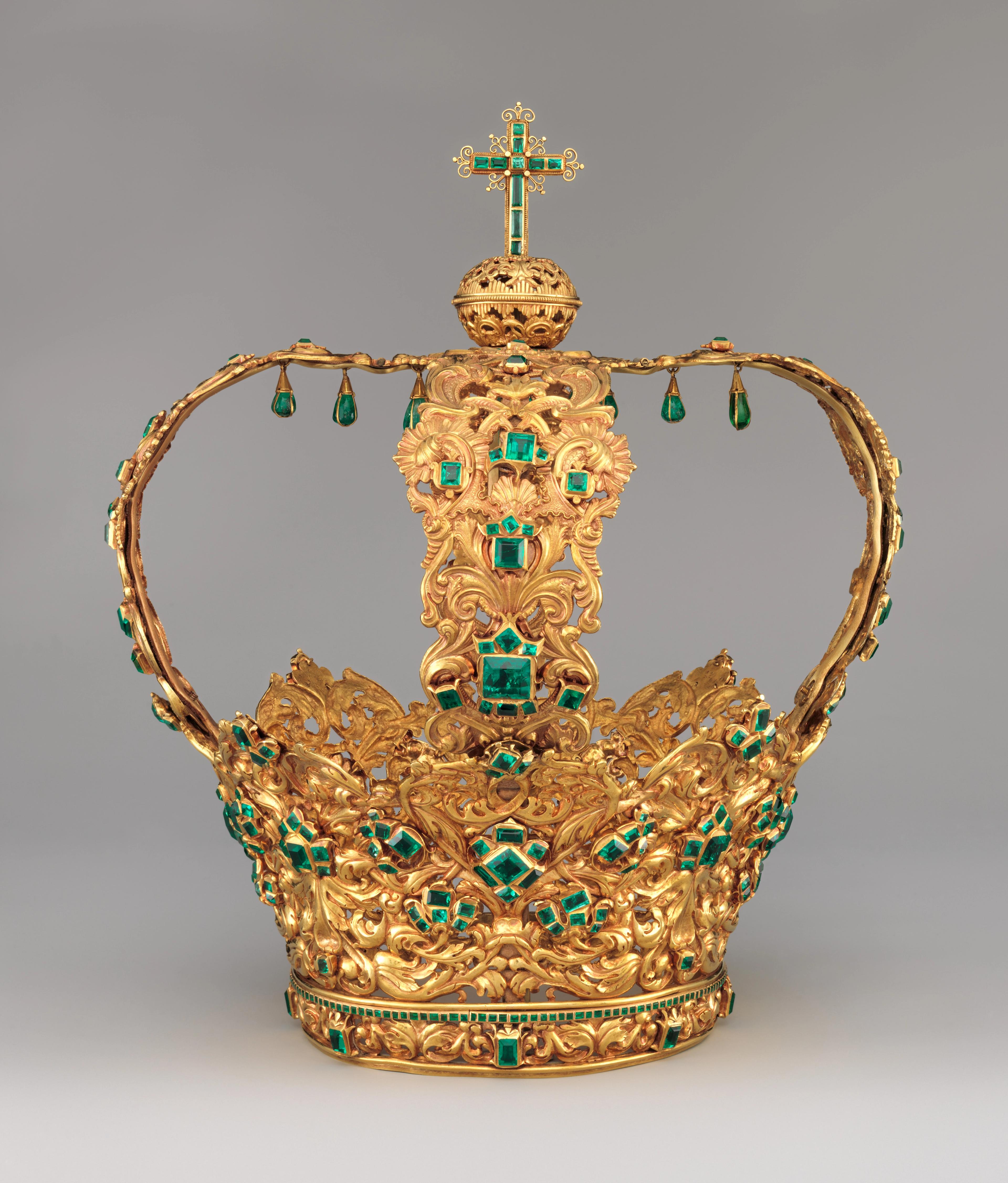 Ornate gold royal crown with emeralds, pearl-like ornaments, jeweled cross, and hanging green pendants; lavish, regal design on gray.