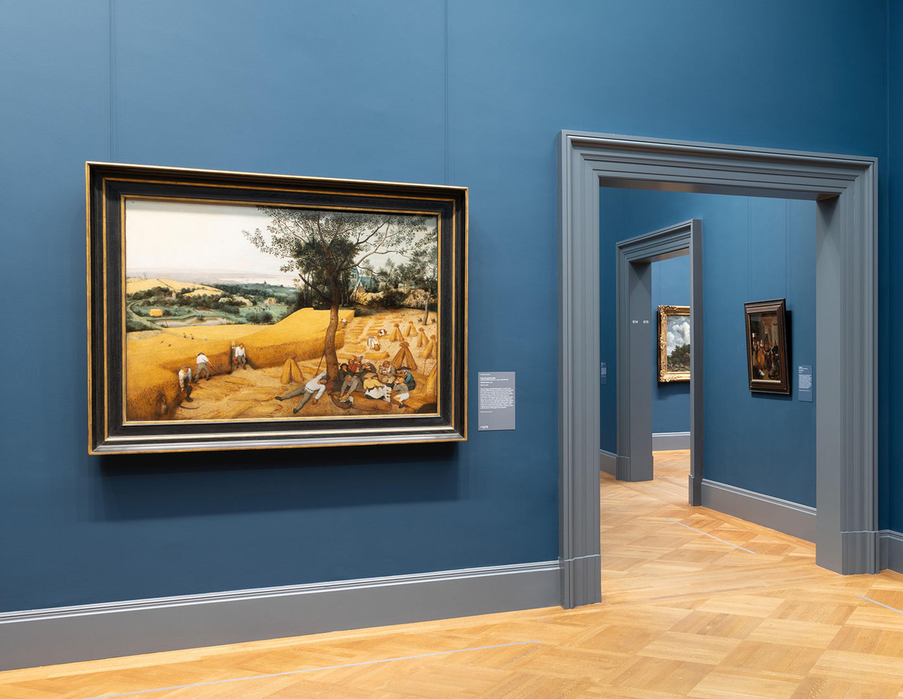 A painting hangs to the left of a doorway in a European Paintings gallery with deep blue walls.