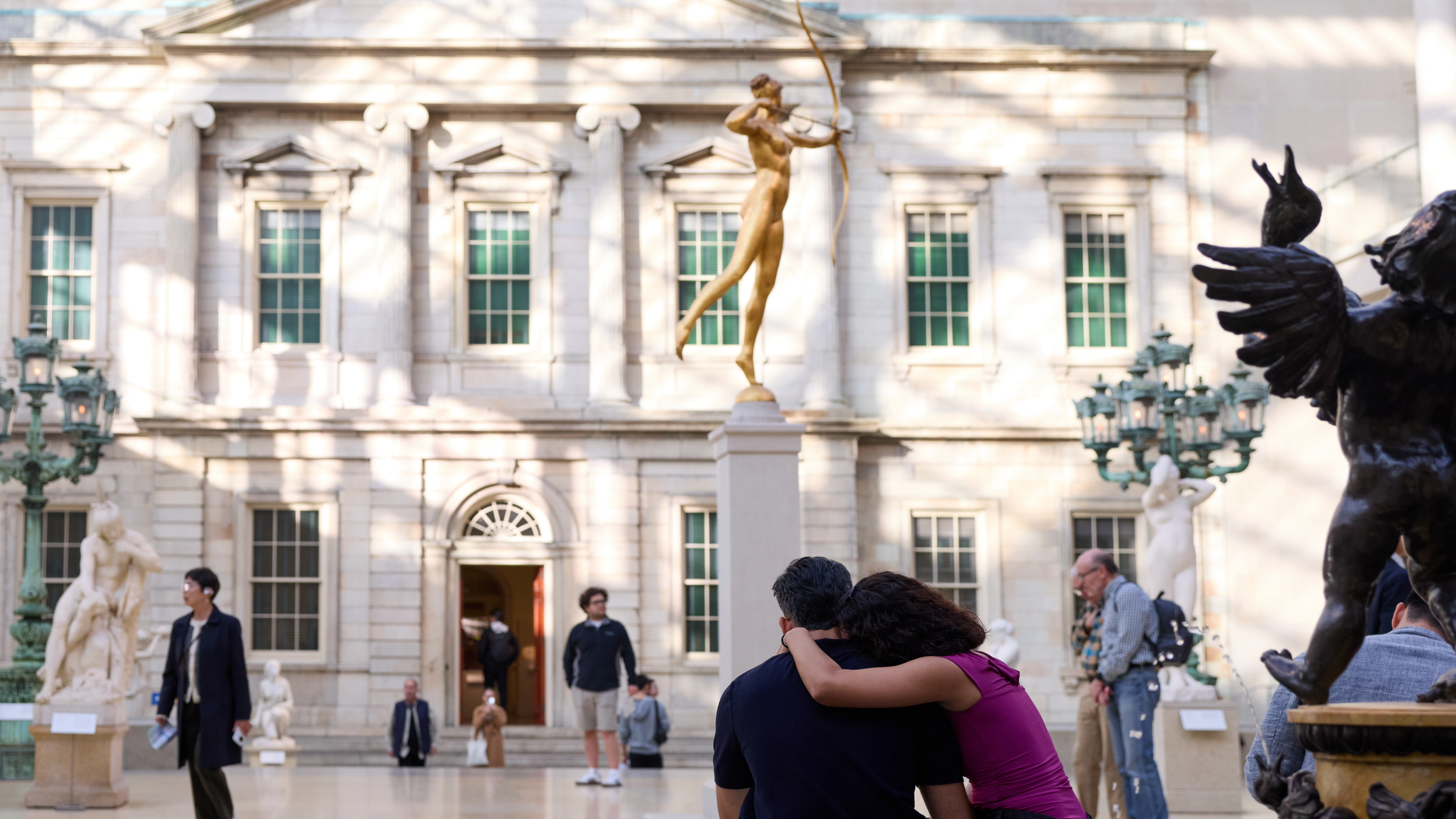 Two people run up The Met Steps at dusk.