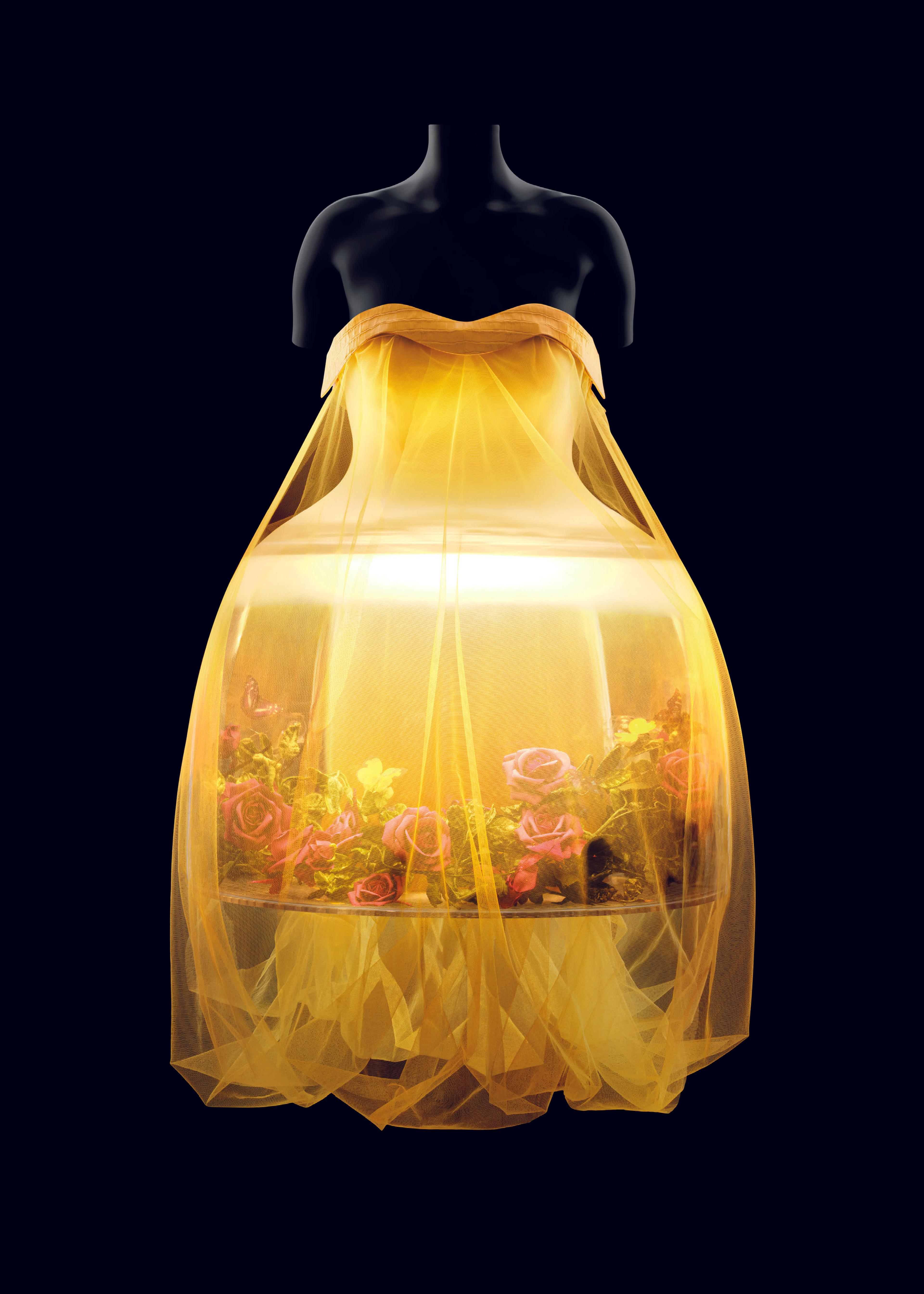a translucent yellow dress, lit from the inside, on a transparent mannequin, against a black background