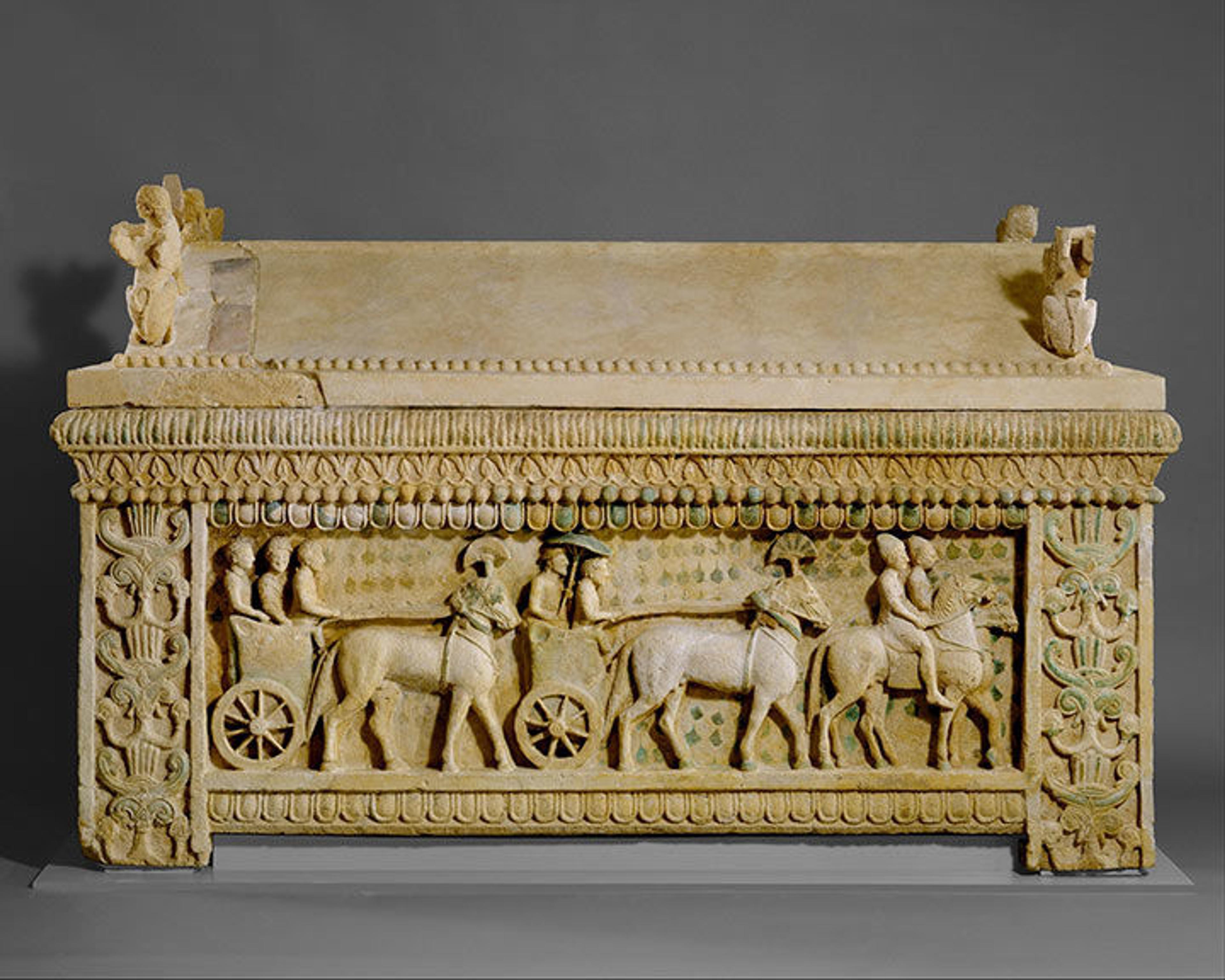 Limestone sarcophagus from the 5th century BC carved with horses pulling chariots