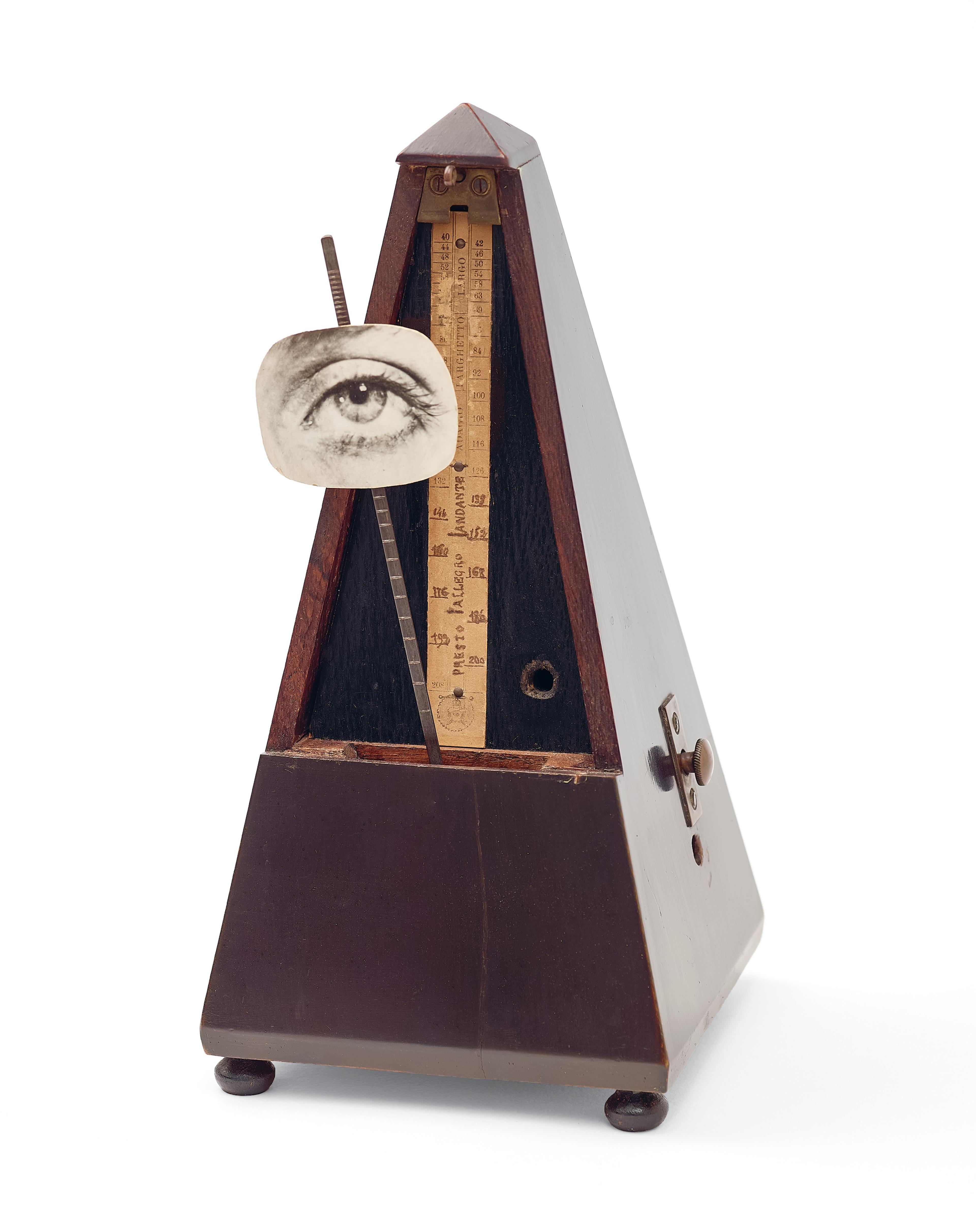 Metronome with a black and white photograph of an eye pasted to the pendulum rod.