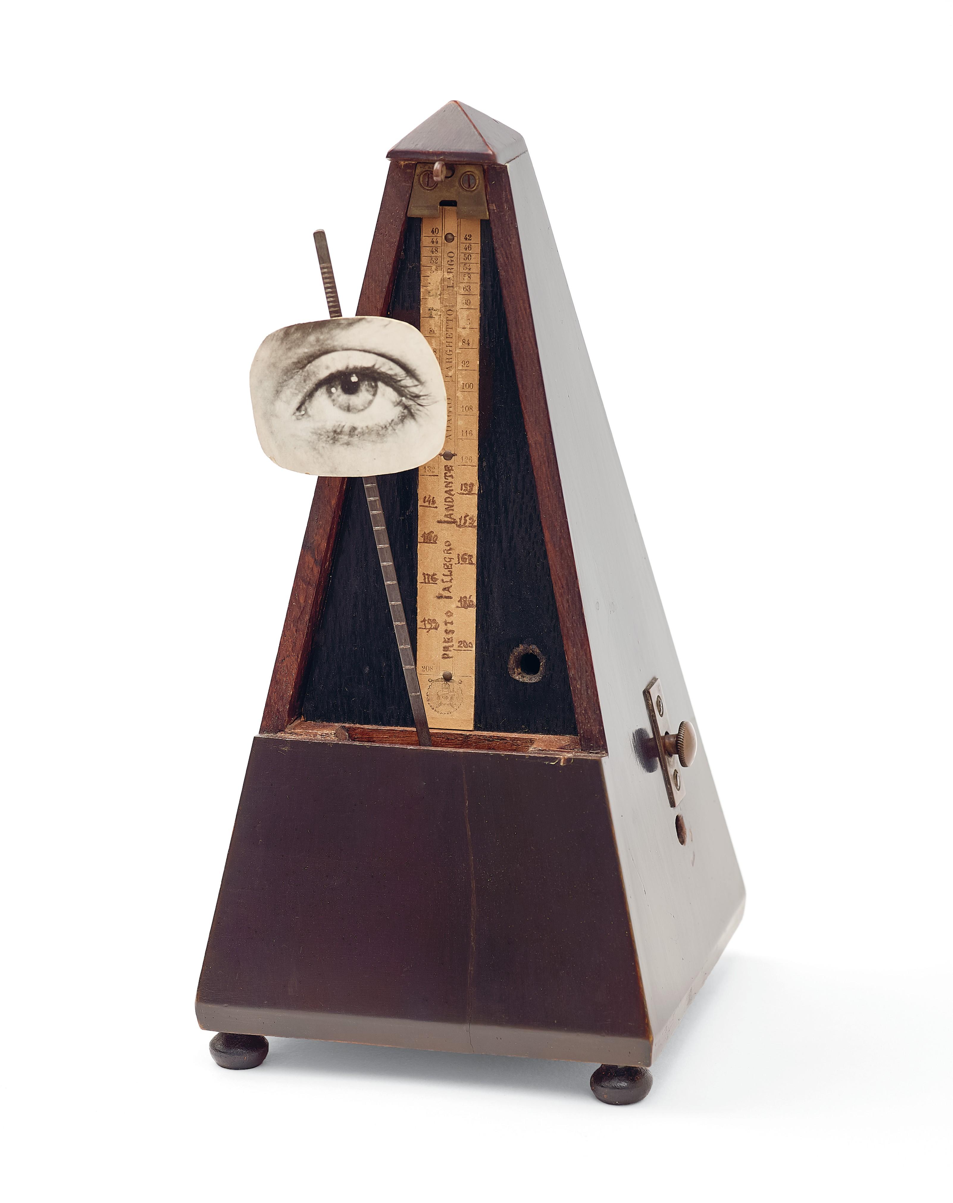 Metronome with a black and white photograph of an eye pasted to the pendulum rod.