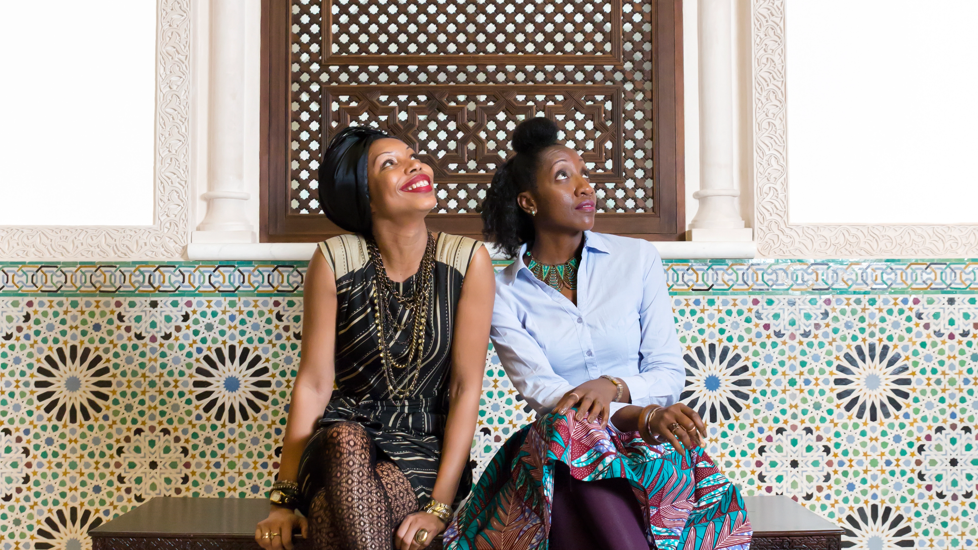 Two women sitting down on a bench.