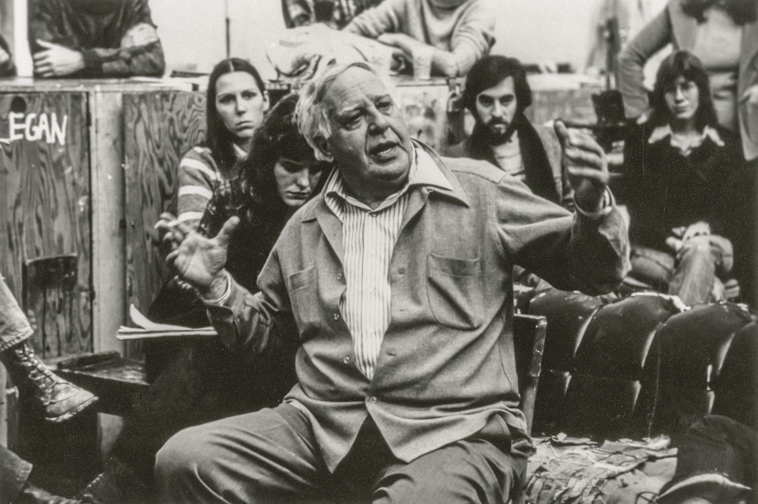 Shot of Guston lecturing with students around him.